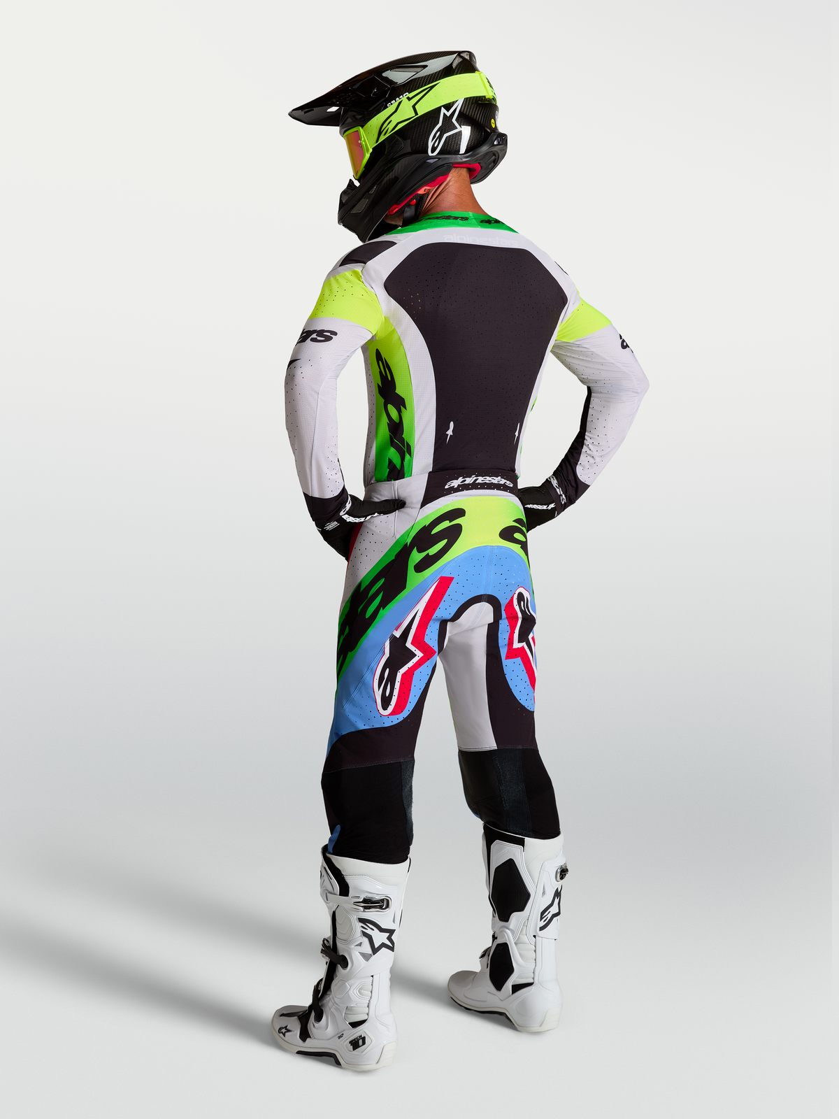 Alpinestars Supertech Dyna, equipo de motocross en verde fluo, negro y lila claro con jersey y pantalones, vista trasera