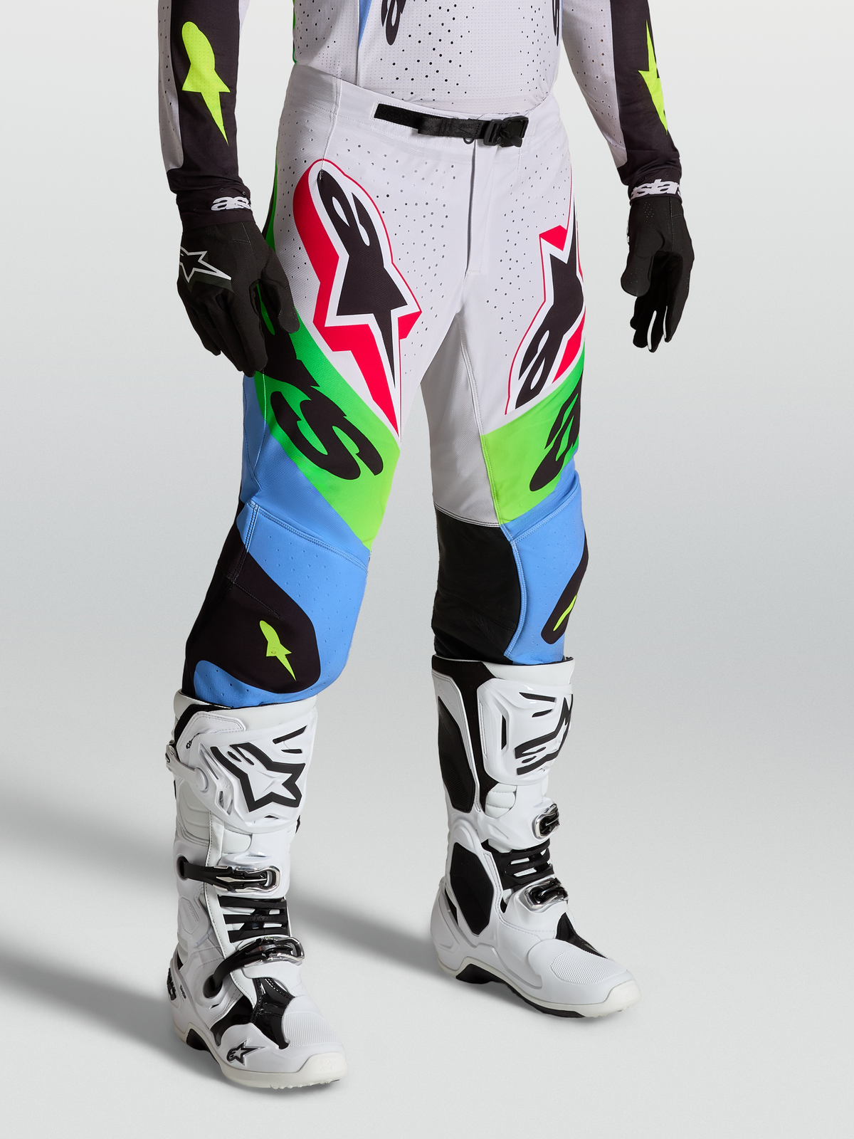 Alpinestars Pantalones Supertech Dyna, pantalones de motocross profesionales, verde y azul, diseño atlético todoterreno, usados con botas blancas y guantes negros