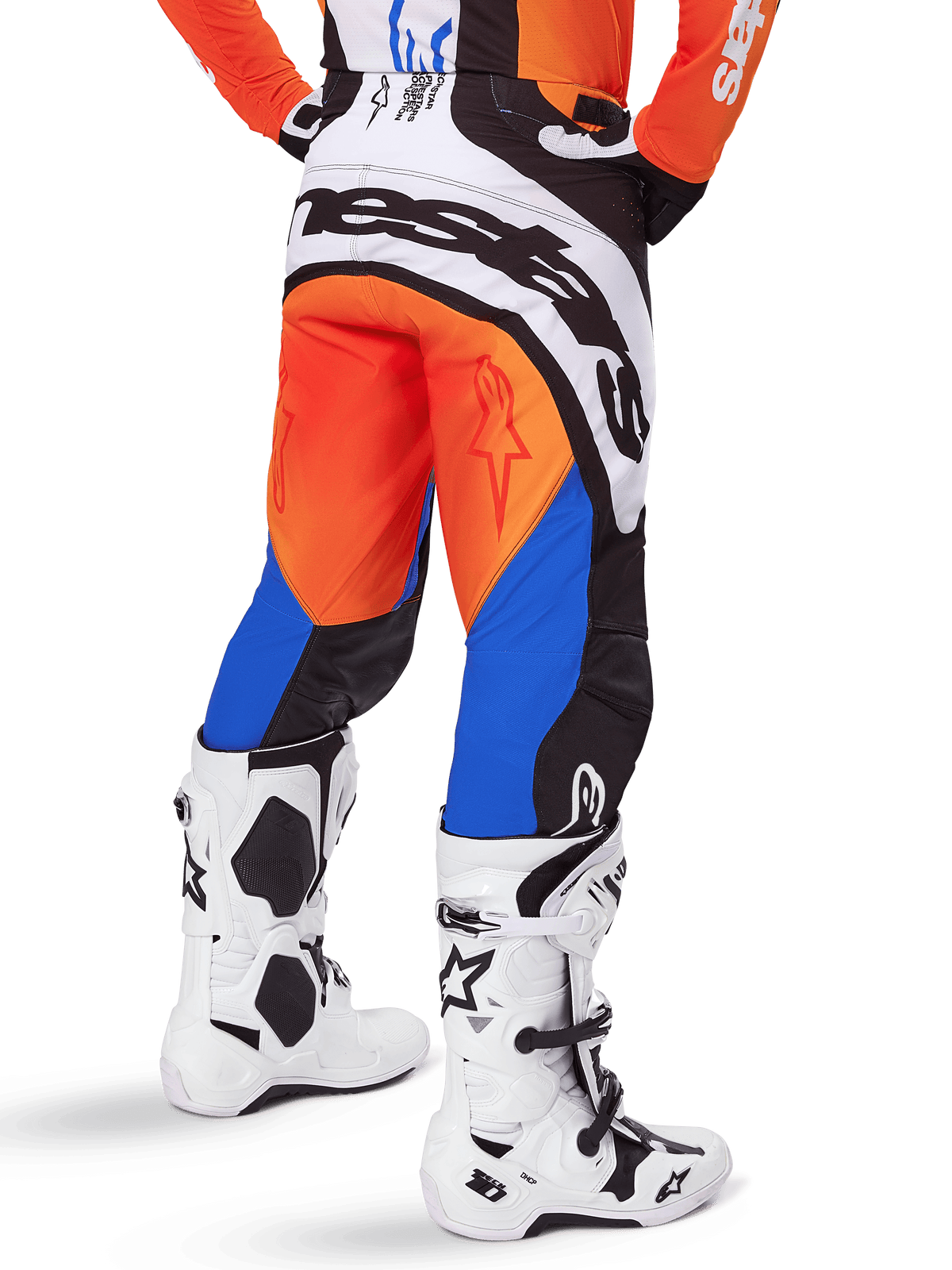 Alpinestars Techstar Melt Pants 2025, pantalones de motocross, naranja y azul, vistos desde atrás con un gran logotipo blanco en el asiento, usados con jersey naranja a juego y botas Tech 10 blancas, equipo de carreras todoterreno duradero