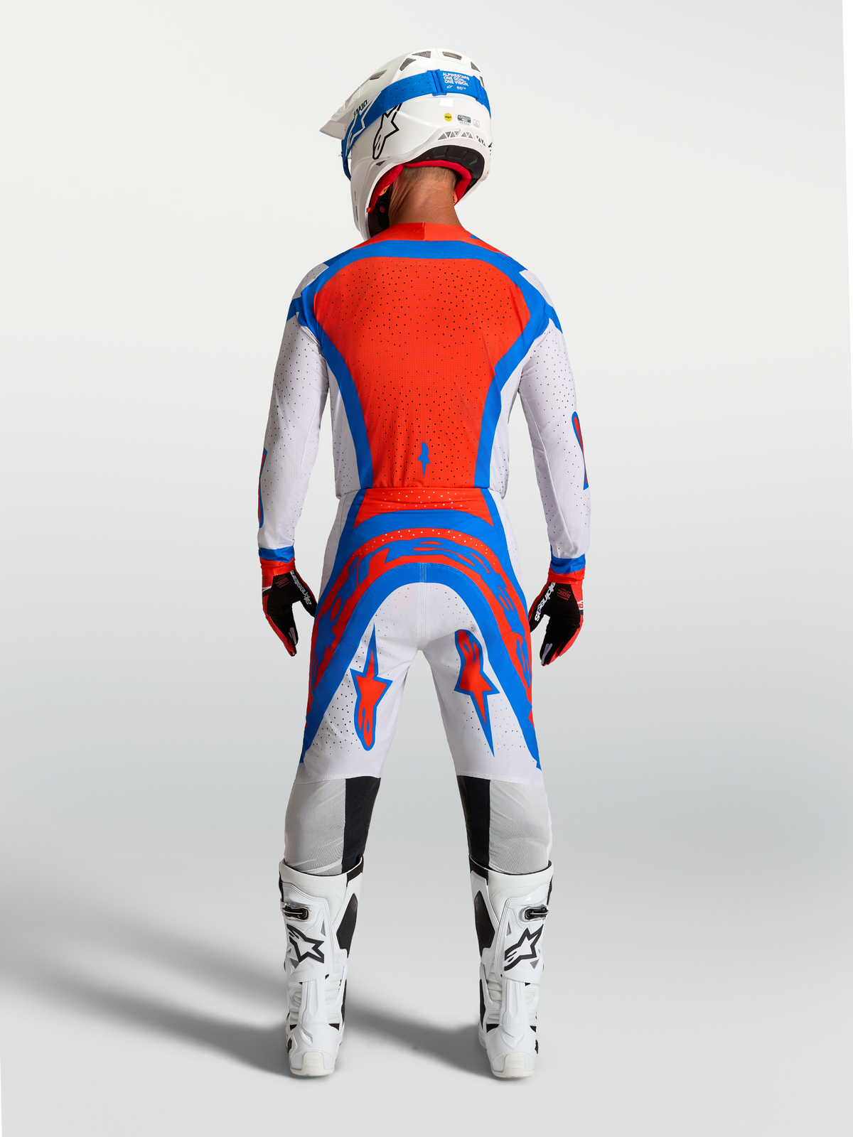 Pantalones Alpinestars Supertech Vesta de motocross, lila claro y rojo, vista trasera en modelo con ajuste atlético.