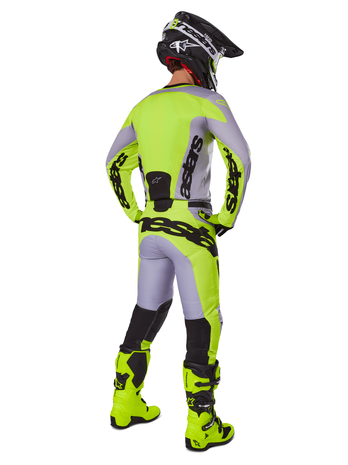 Alpinestars 2025 Racer Veil Pants, pantalones de motocross, gris y amarillo fluorescente, vista trasera de piloto con el equipamiento completo, jersey a juego y botas amarillo flúor, con logotipos negros llamativos, kit técnico de carreras off-road
