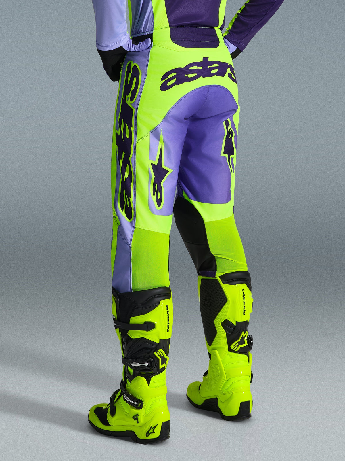 Alpinestars 2026 Racer Portl Pants, pantalones de motocross, púrpura y amarillo flúor, vista trasera con logotipo astars llamativo y detalles en púrpura, usados con botas de motocross amarillo flúor a juego, material sintético duradero para carreras off-road