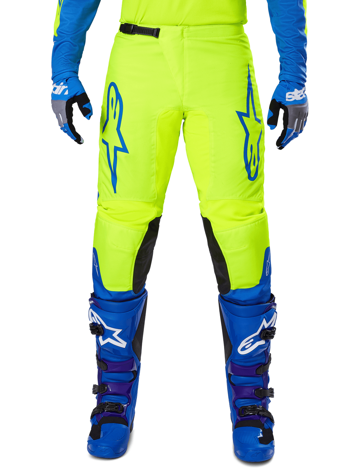 Alpinestars 2025 Fluid Haul Pants, pantalones de motocross, amarillo brillante y azul, usados con guantes y botas a juego, con paneles negros en el interior de la rodilla, logotipos azules llamativos en los muslos y un diseño ergonómico deportivo