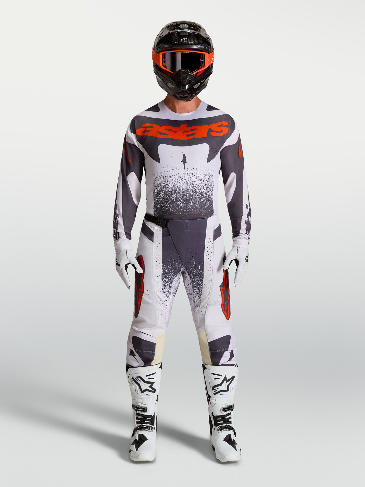 Pantalones Alpinestars Techstar Swan, equipo de motocross para hombre en lila claro, gris y rojo flúor con botas blancas.