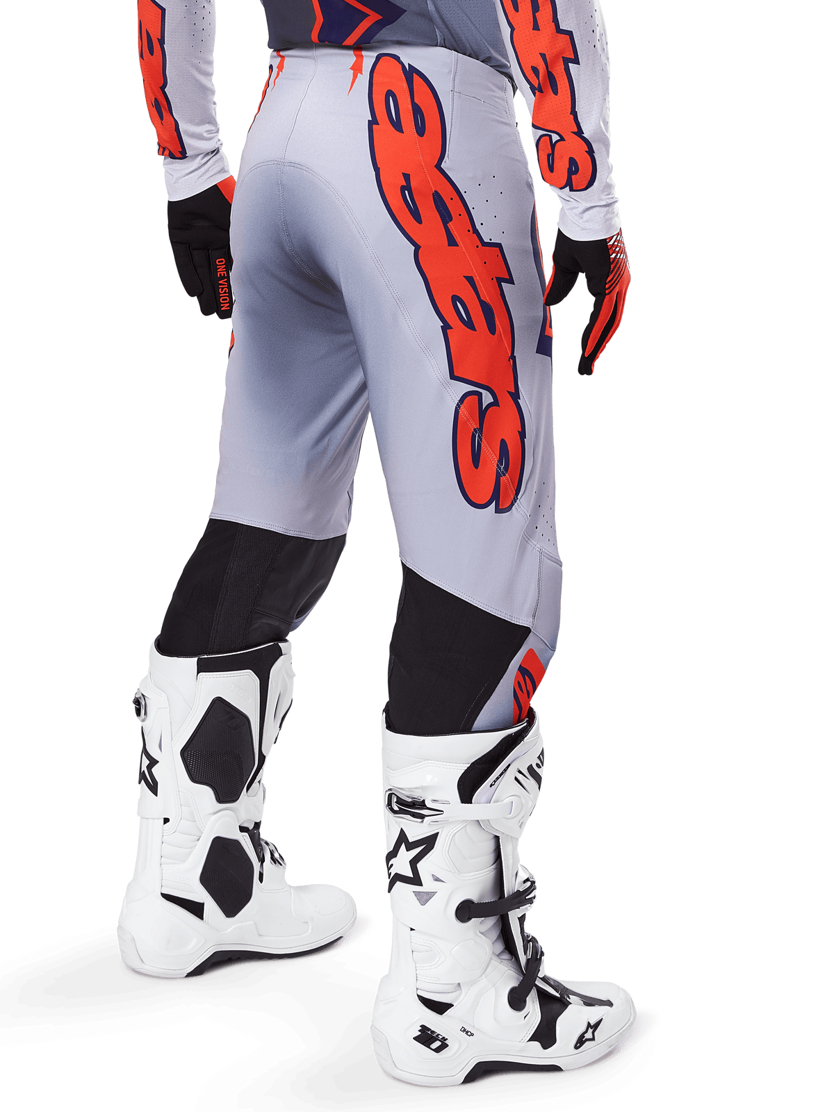 Alpinestars 2025 Supertech Lipan Pants, pantalones de motocross, gris y naranja flúor, vista trasera con un gran gráfico naranja de Alpinestars, paneles elásticos negros, usados con jersey a juego y botas blancas, equipamiento profesional de motocross