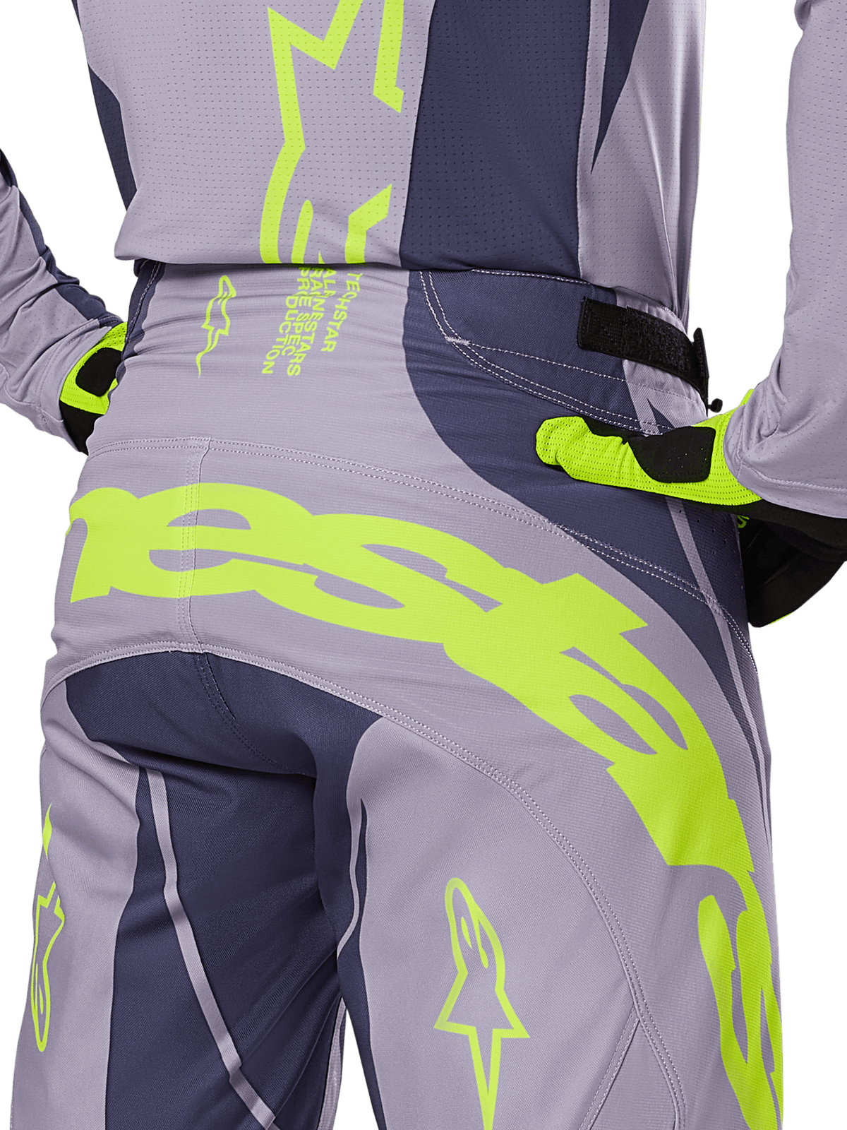 Alpinestars Techstar Dreem Pants 2025, pantalones de motocross, gris y gris oscuro con detalles en amarillo fluorescente, vista posterior que muestra el llamativo logotipo de Alpinestars en el canesú, usados con jersey y guantes a juego, diseñados para competición todoterreno