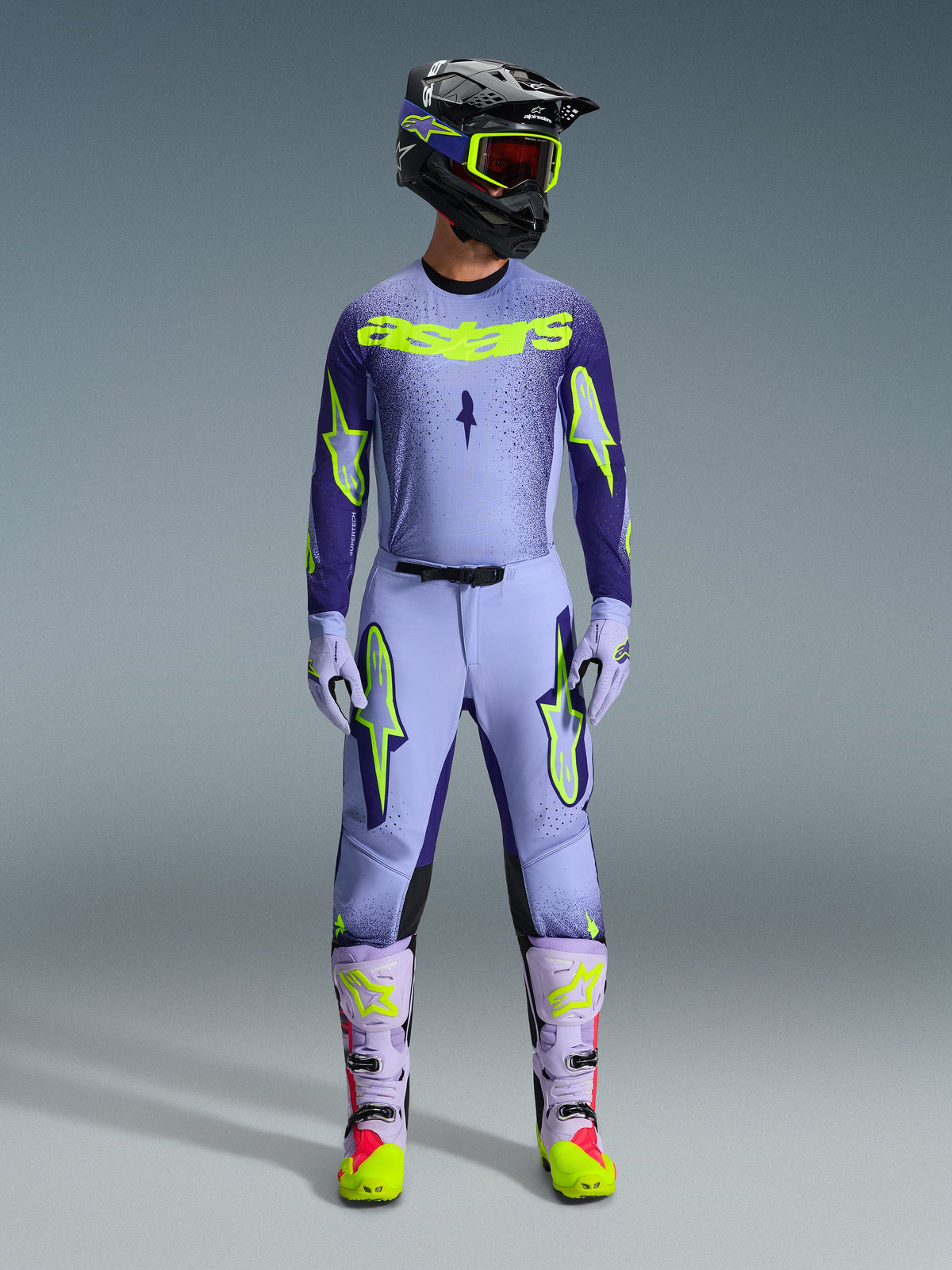 Alpinestars 2026 Supertech Scenz Pants, Motocross Pants, Purple Yellow Fluo, worn as a complete racing gear set with matching lavender jersey, gloves, and boots, featuring bold yellow fluo logos, athletic fit design for professional off-road racing.
