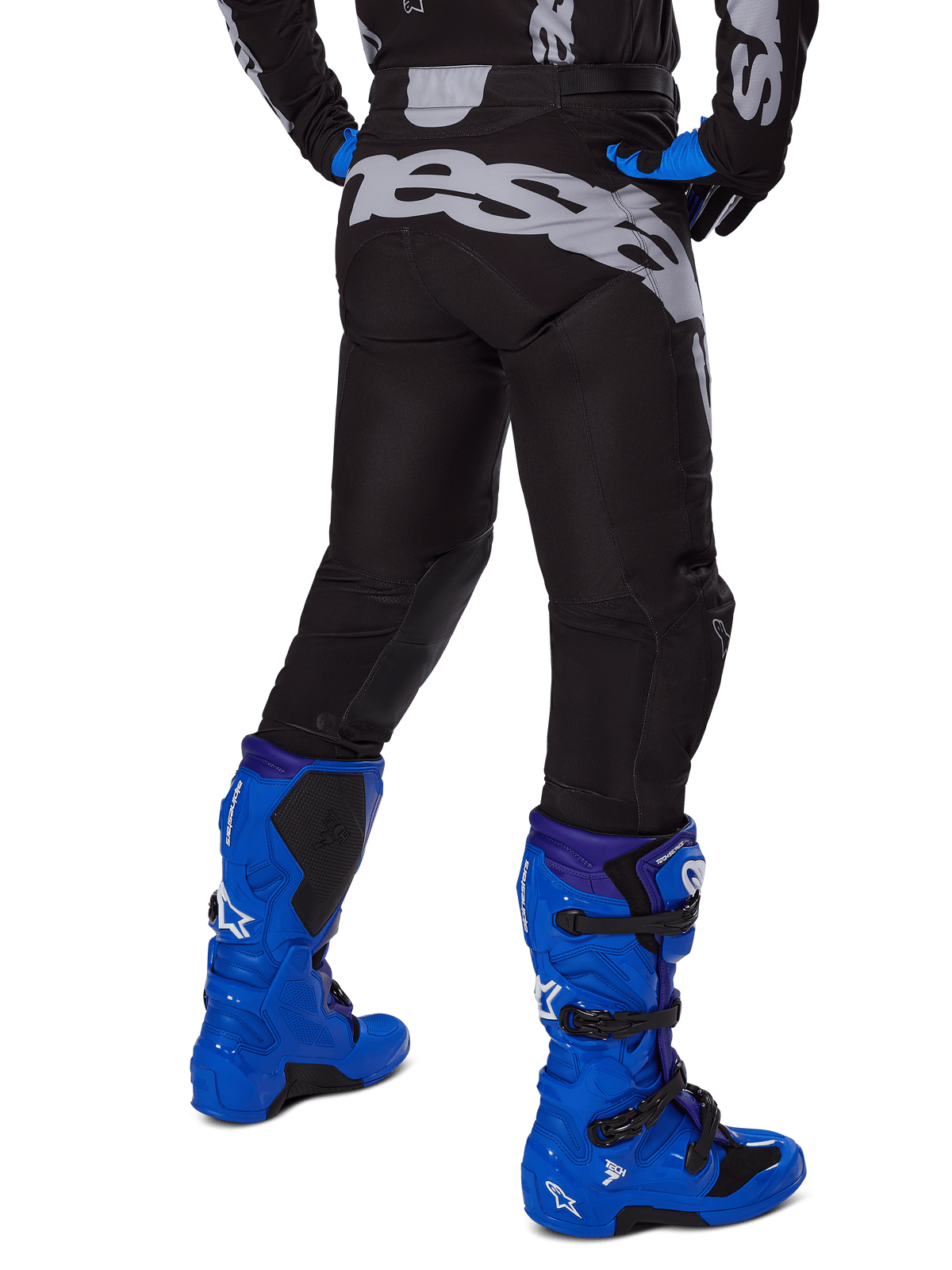 Alpinestars 2025 Racer Graphite Pants, Motocross Pants, Black and Gray, rear view with large gray branding on the seat, worn with bright blue motocross boots and black and blue jersey, durable off-road racing gear