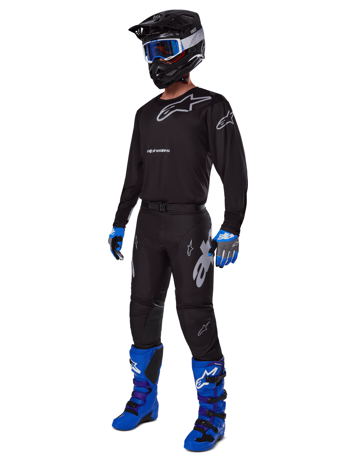Motocross rider wearing complete Alpinestars racing gear, 2025 Racer Graphite Pants in Black and Gray, matching black jersey with grey logos, black helmet with blue goggles, bright blue and purple boots, and blue and grey gloves, coordinated outfit for off-road racing