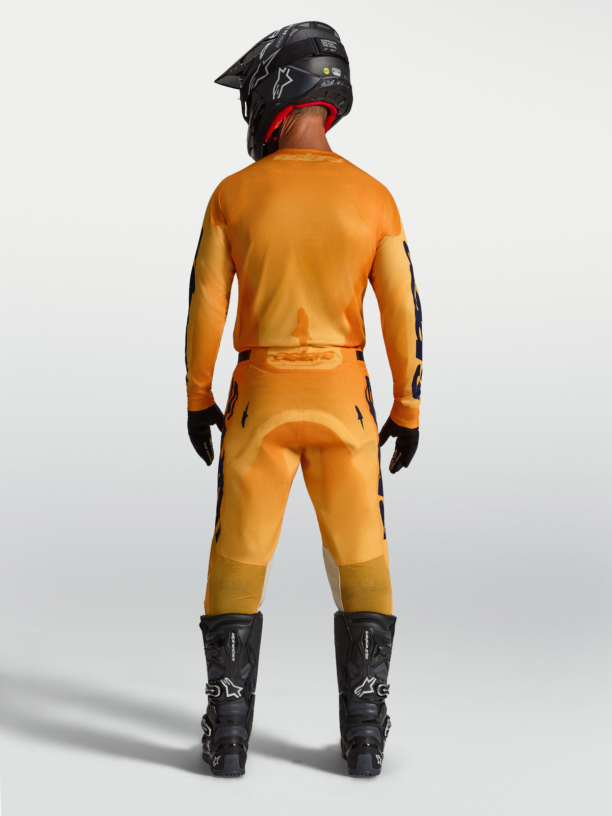 Pantalones Racer Amber de Alpinestars, equipo de motocross para hombre, naranja y azul, vista trasera, construcción duradera.