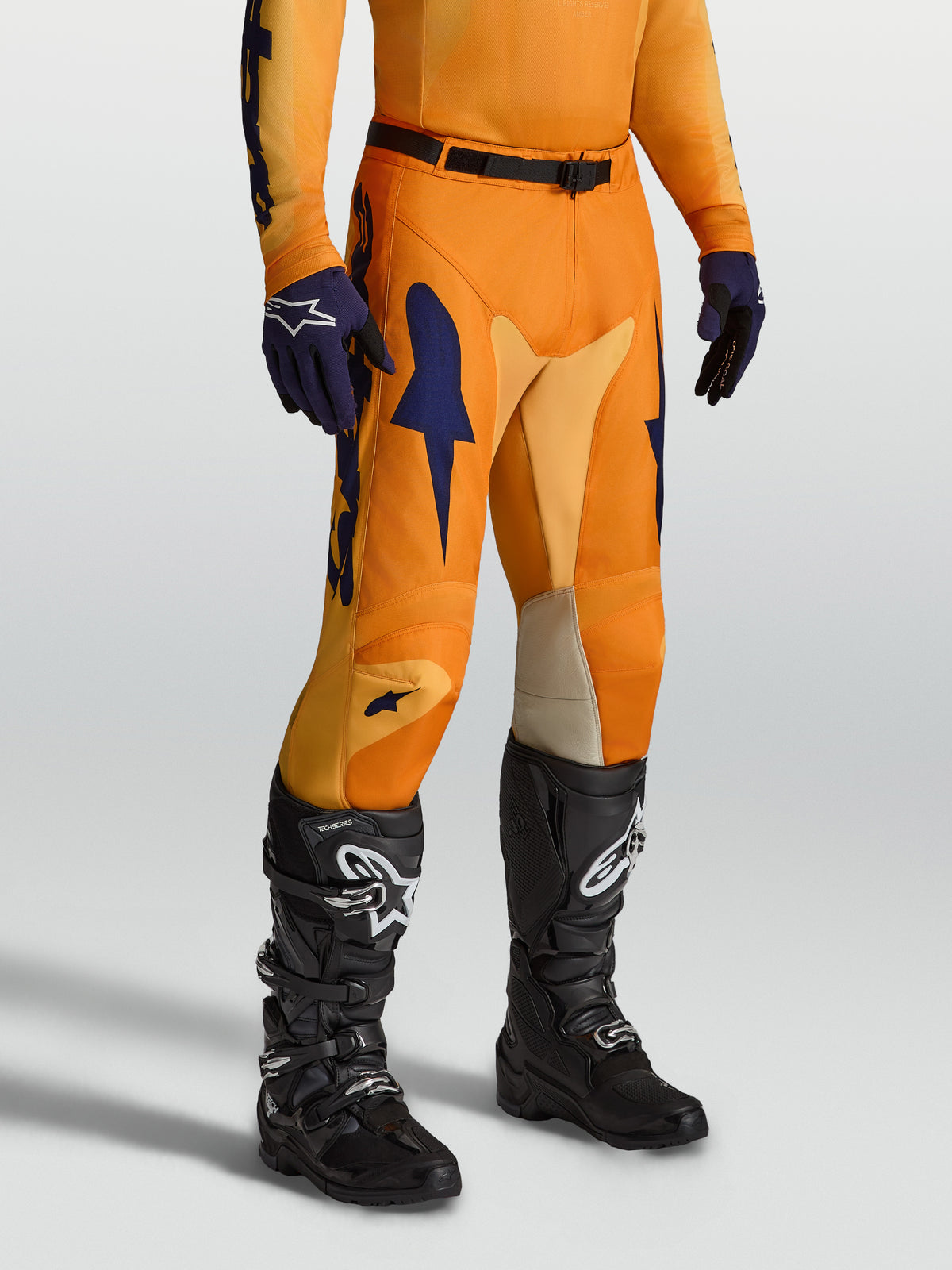 Alpinestars Racer Amber, pantalones de motocross de hombre, naranja y azules, con inserciones elásticas y diseño ergonómico.
