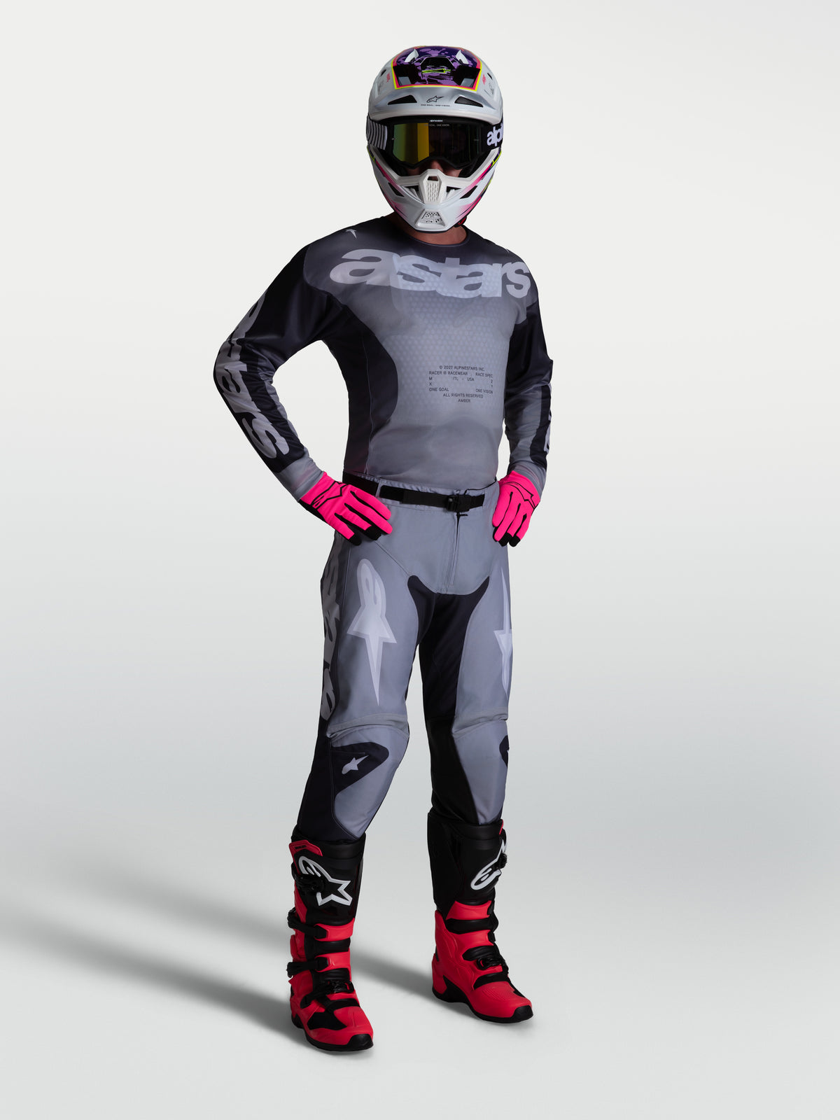 Pantalones Racer Amber de Alpinestars y equipo de motocross para hombre en gris y rosa, ropa técnica duradera para carreras off-road.