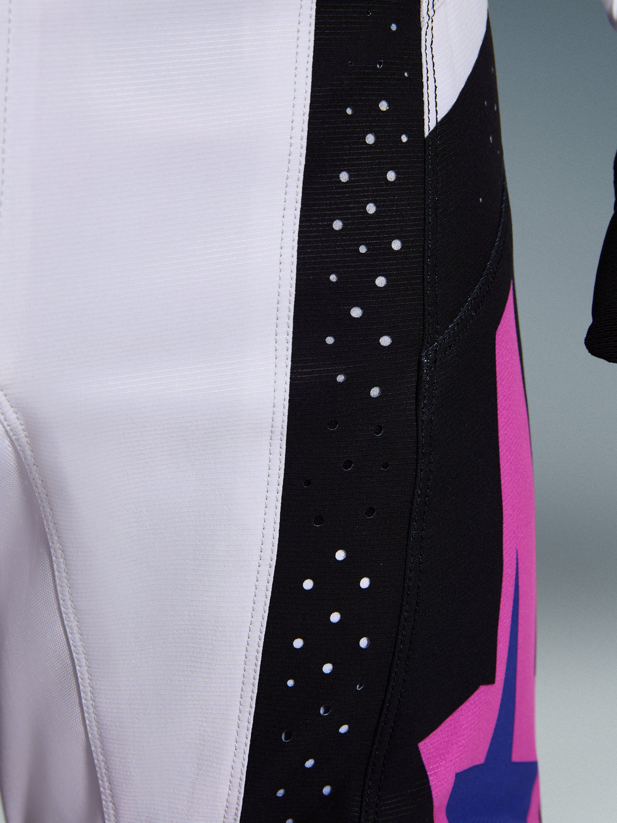 Alpinestars 2026 Techstar Knif Pants, pantalones de motocross, negro, gris claro y púrpura, detalle en primer plano que muestra perforaciones cortadas con láser en el panel lateral negro para ventilación, construcción en tejido ripstop duradero