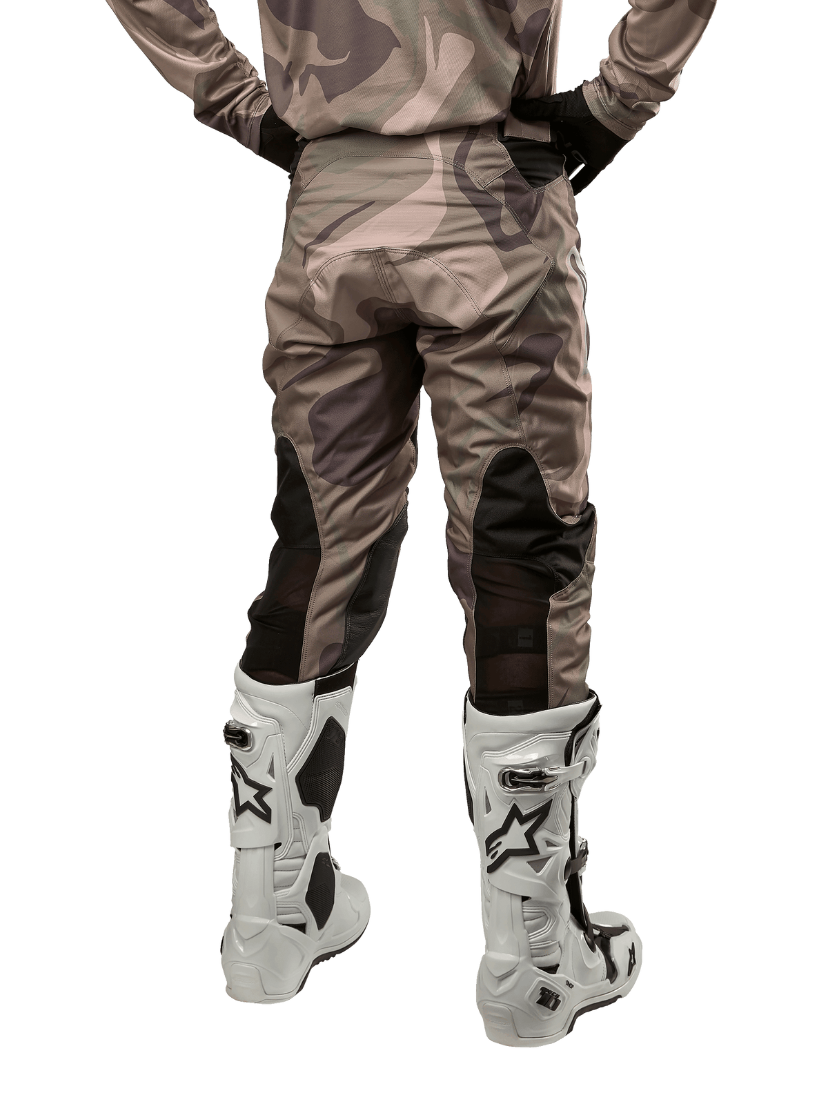 Alpinestars 2024 Racer Tactical Pants, pantalones de motocross, camuflaje verde militar y marrón, vista trasera que muestra el patrón de camuflaje y paneles elásticos transpirables negros en la parte inferior de las piernas, usados con botas de motocross blancas, equipo técnico duradero para conducción todoterreno