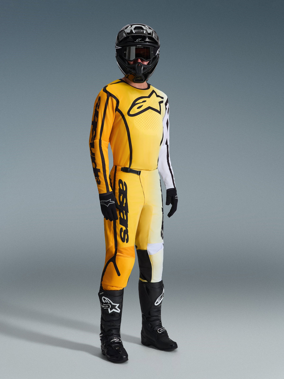 Alpinestars 2026 Fluid Apex Pants, pantalones de motocross amarillos y negros, combinados con un jersey amarillo y blanco a juego, casco negro, gafas, guantes y botas negras, con logotipos llamativos en negro y un diseño degradado moderno para carreras off-road.