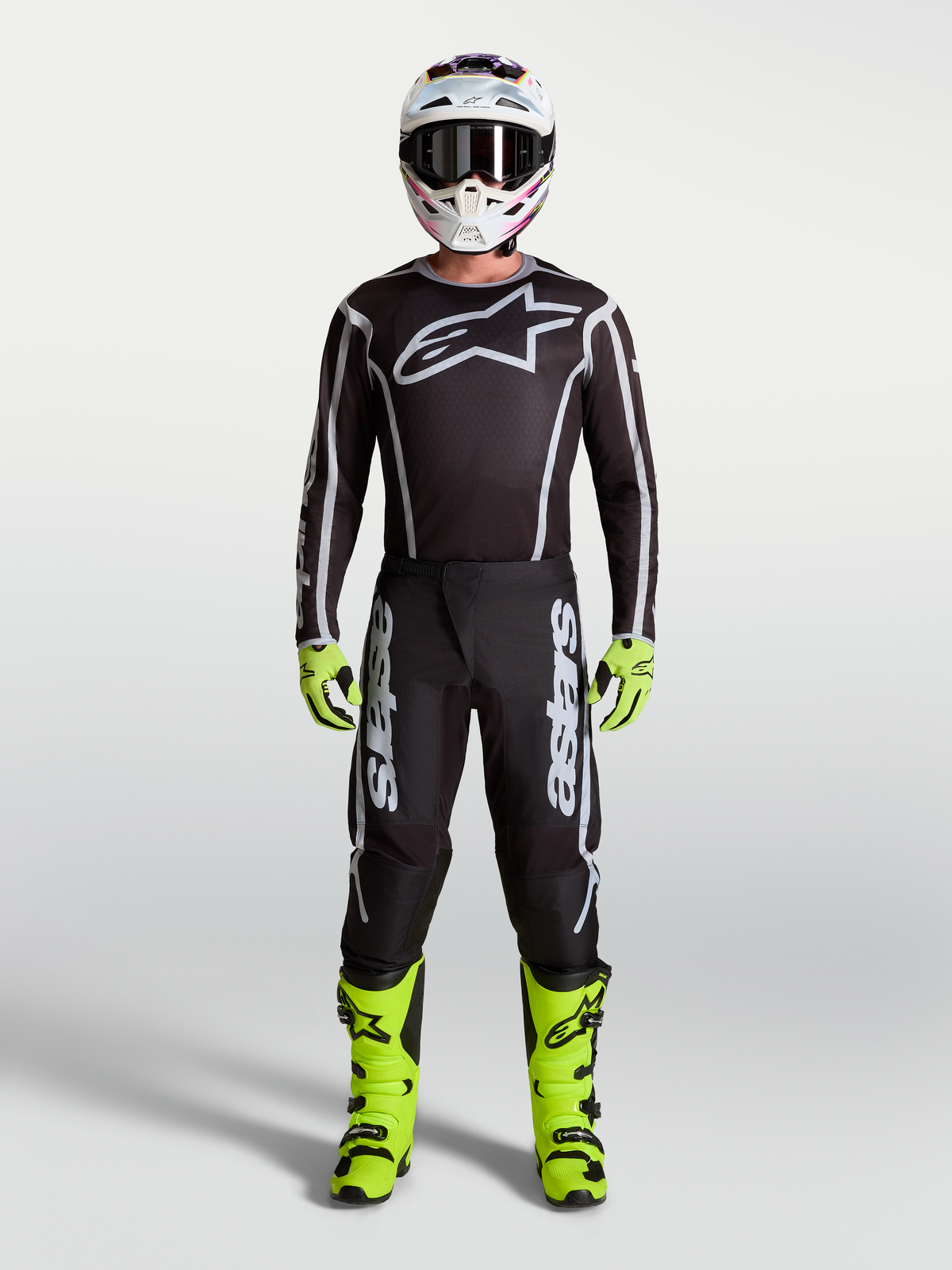 Alpinestars Fluid Apex V2 Pants in Black and Silver, part of a full Men's Motocross gear set with neon yellow boots, helmet, and performance racing jersey.