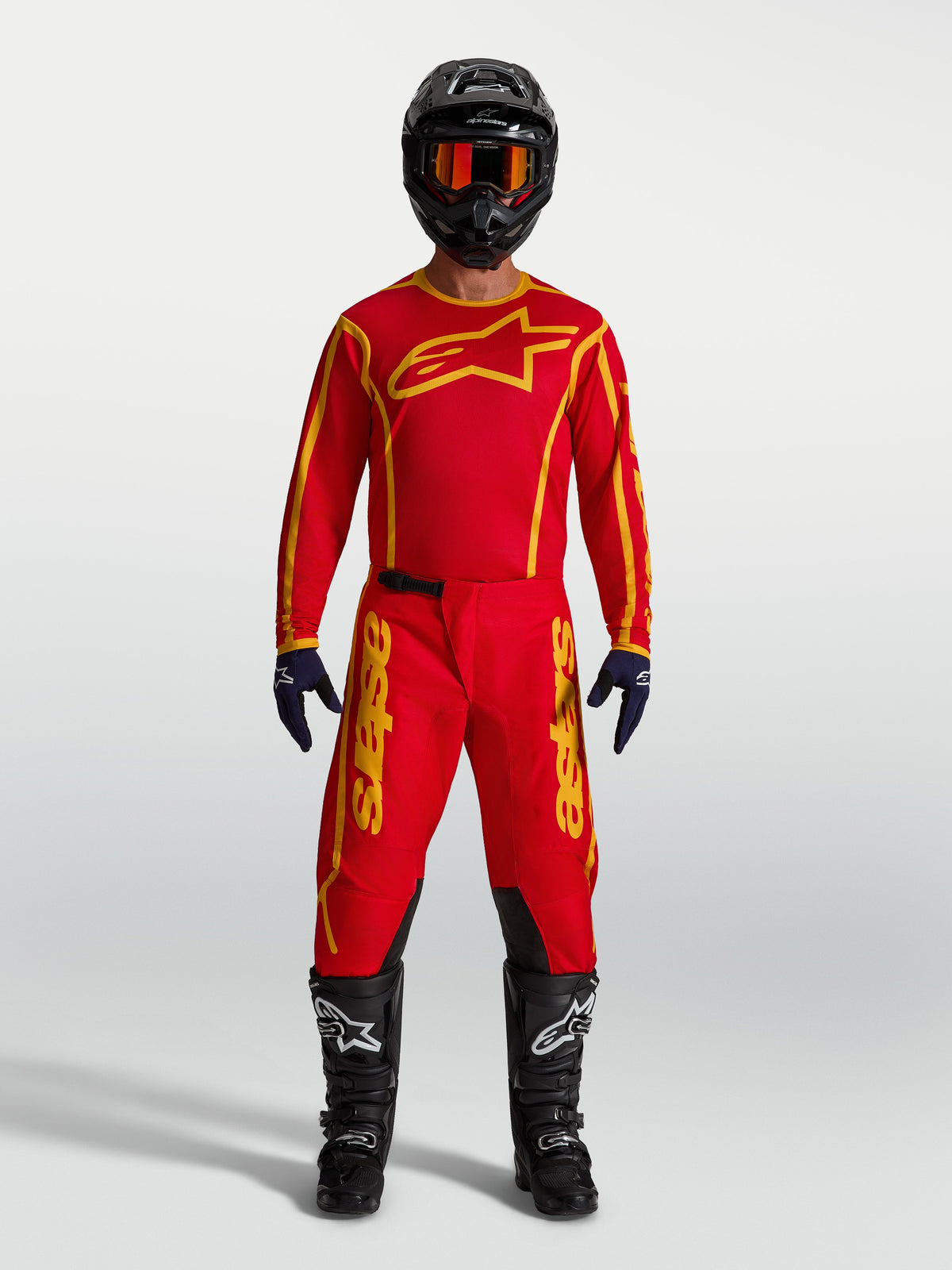Alpinestars Fluid Apex V2 Pants, Men's Motocross Gear in Fire Red and Gold with matching jersey, black helmet, and boots.