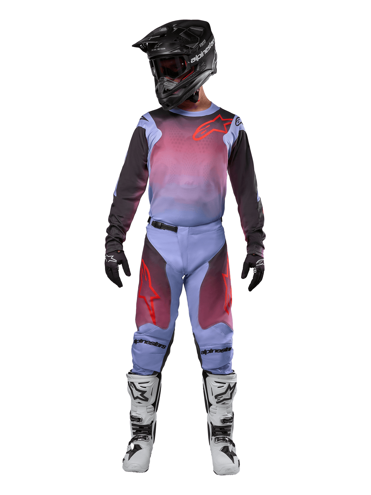 Piloto de motocross con equipamiento completo de competición, jersey y pantalones Alpinestars 2024 Racer Hoen, en color Lavan Purple y negro con detalles rojos, casco negro, botas blancas y negras, y guantes negros, conjunto coordinado para carreras todoterreno.