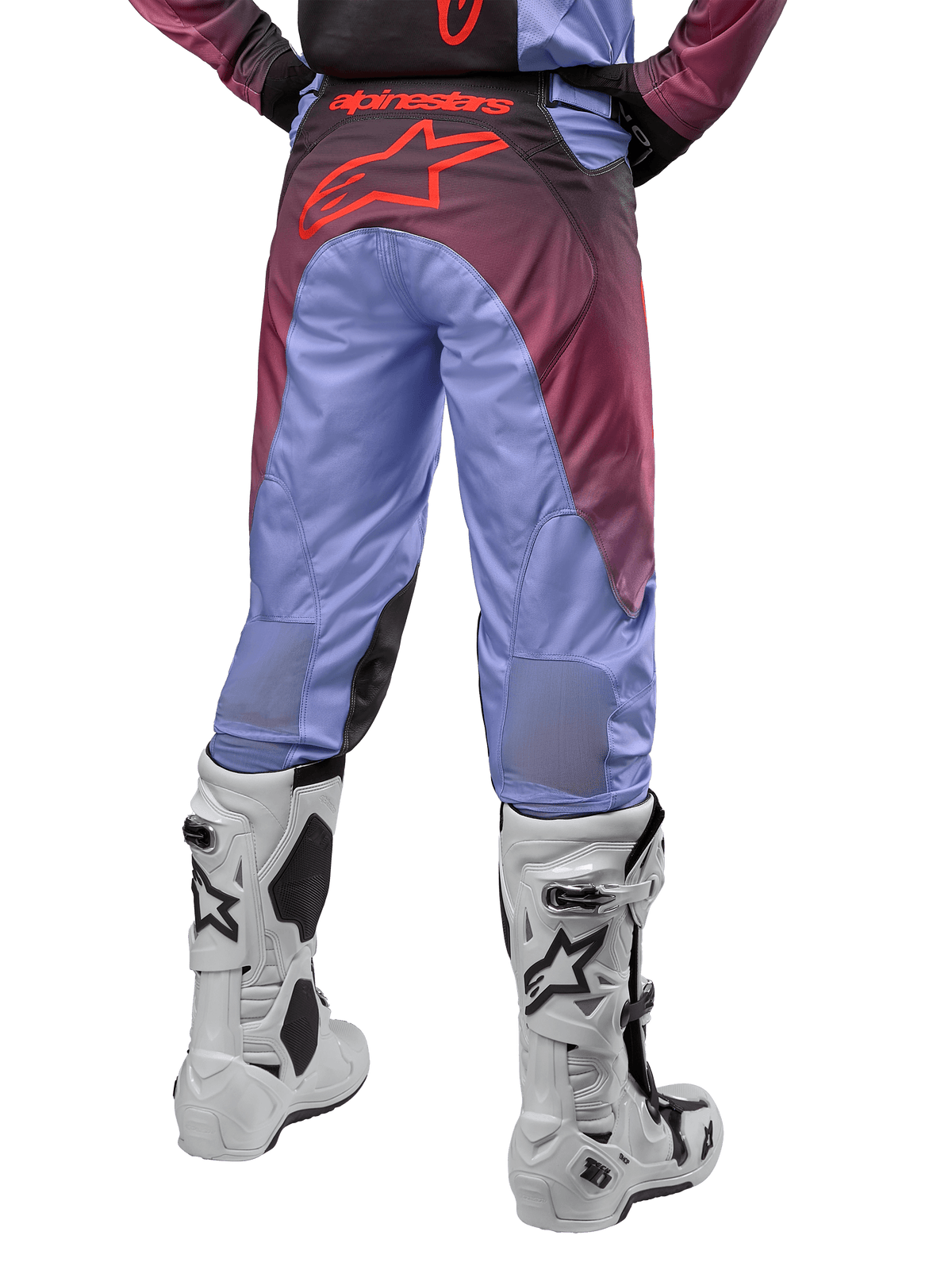 Alpinestars 2024 Racer Hoen Pants, pantalones de motocross, morado Lavan y negro, vista posterior que muestra un gran logo de estrella roja en el asiento, usados con botas de motocross blancas y paneles elásticos transpirables en la parte inferior de las piernas.