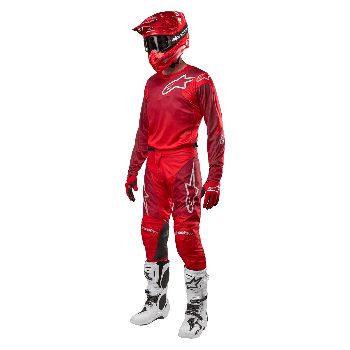 Piloto de motocross con equipamiento completo de competición, pantalones y jersey Alpinestars 2024 Racer Hoen en Mars Red Burgundy, casco rojo, guantes rojos y botas blancas y negras, conjunto coordinado para carreras fuera de carretera