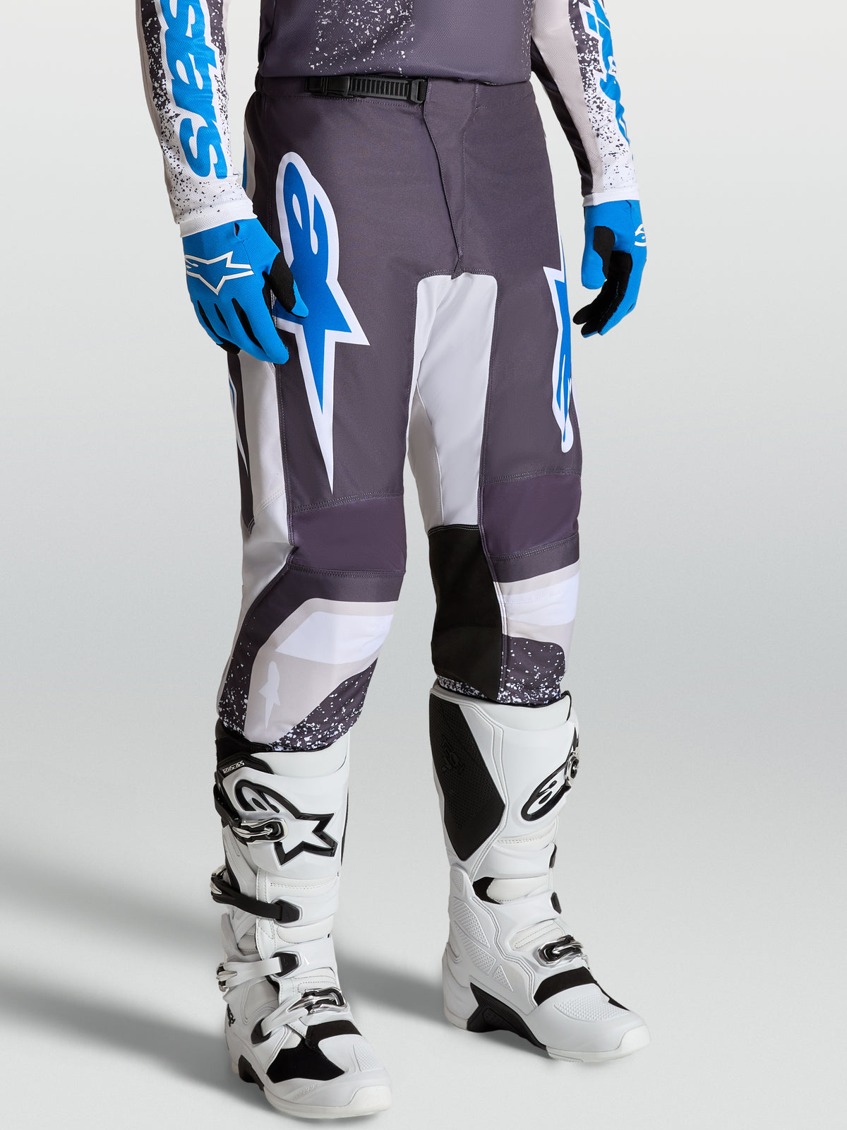 Pantalones Alpinestars Fluid Drag, pantalones de motocross para hombre, gris, lila claro y azul, ajuste deportivo ergonómico, diseño para off-road con piernas precurvadas.