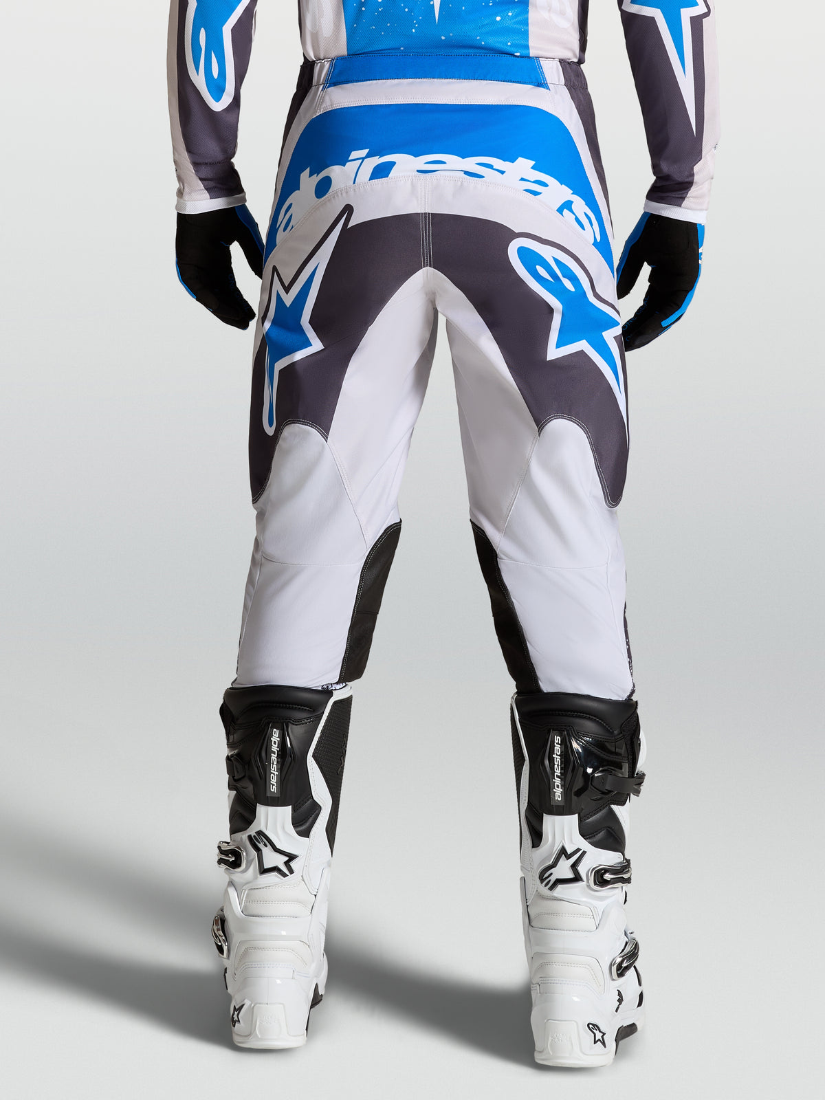 Alpinestars Pantalones Fluid Drag, pantalones de motocross para hombre, gris y azul, vista trasera que muestra el asiento reforzado y diseño ergonómico, equipo para conducción off-road y MX