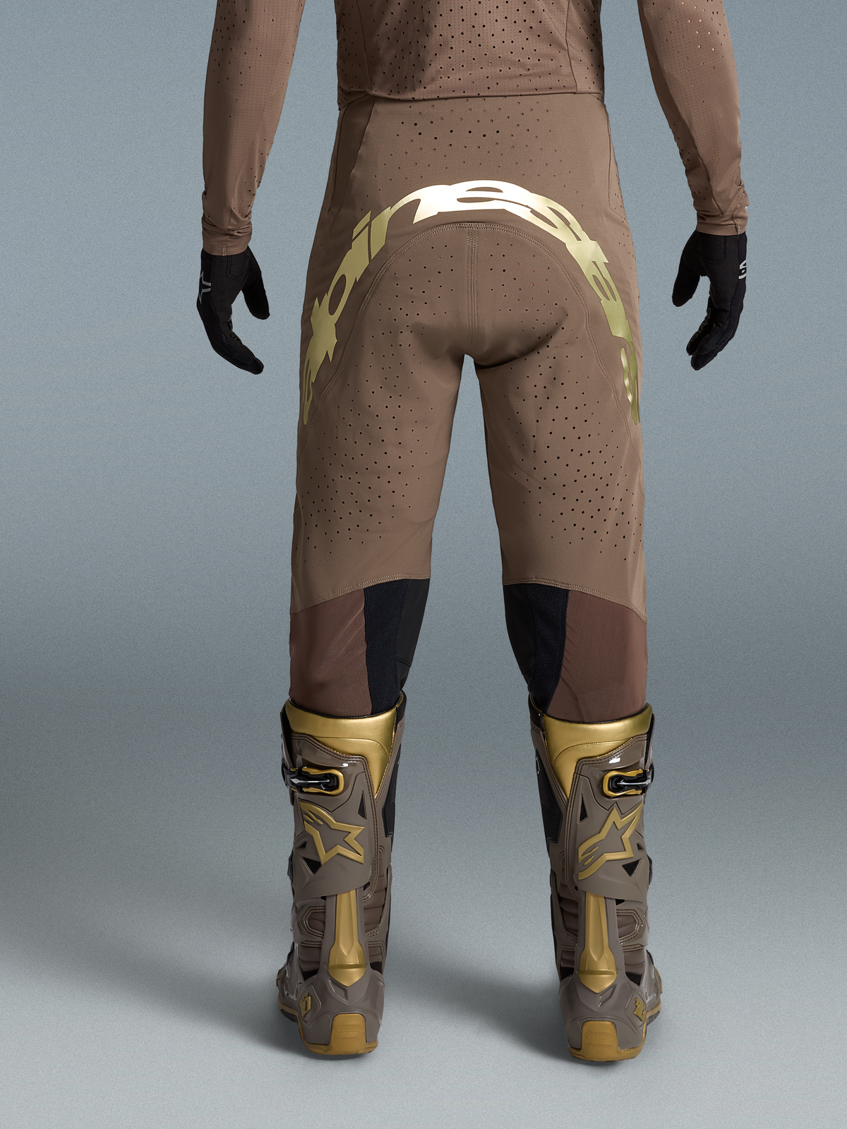 Alpinestars Supertech Air Gold Motocross Pants, brown and gold on-model racing trousers with perforated fabric and limited edition graphics.