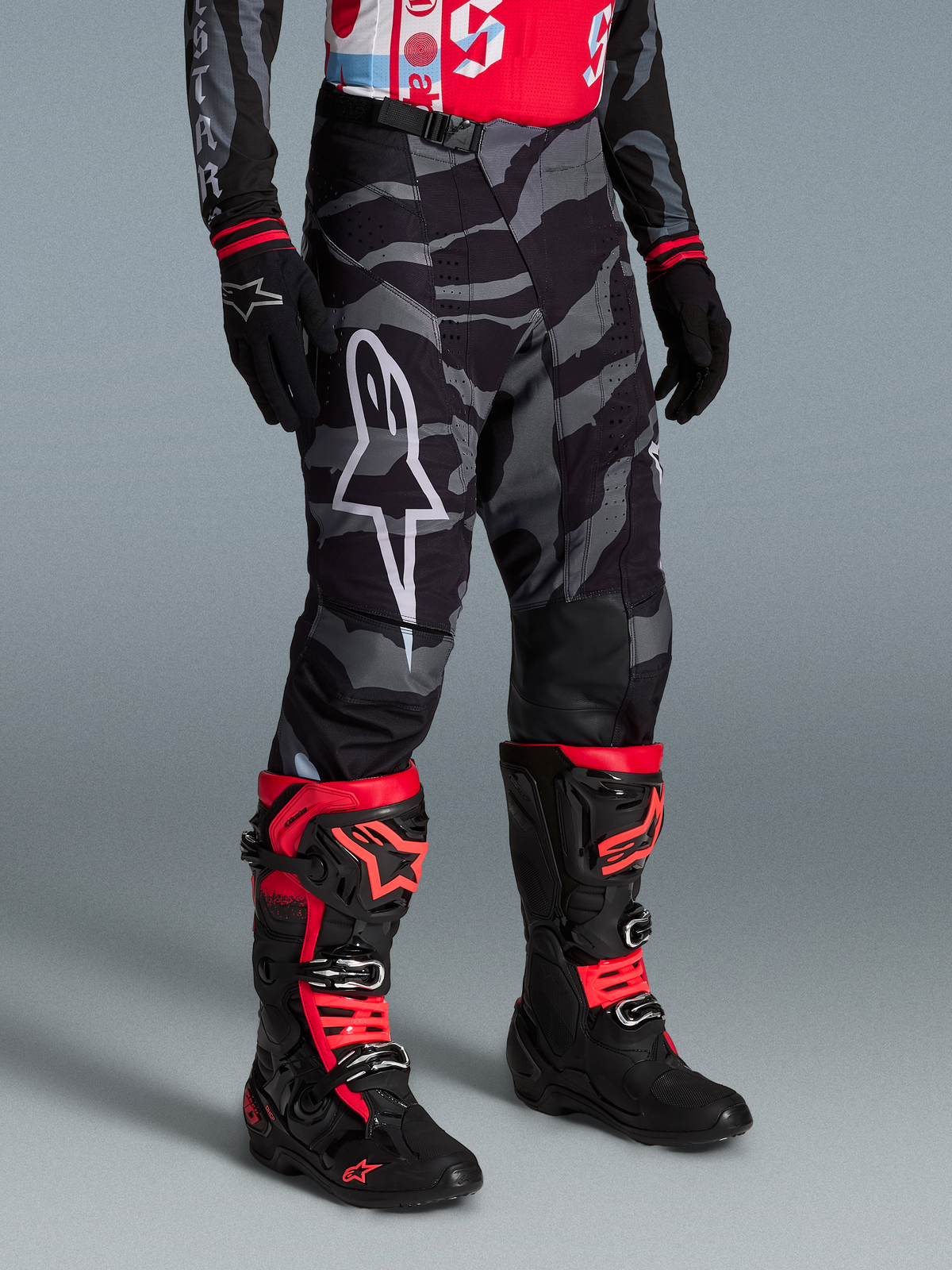 Pantalones Techstar Beast Coast Edición Limitada en camuflaje negro y gris, con botas de motocross rojas y logotipo blanco.