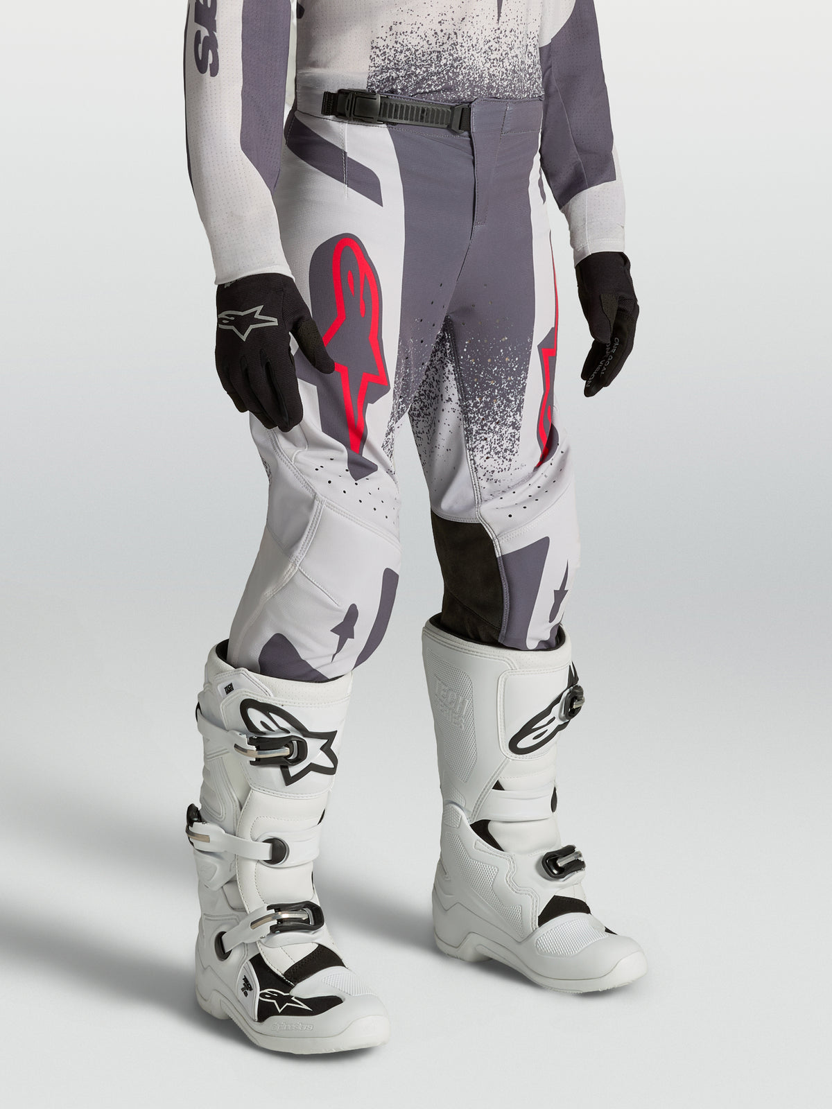 Alpinestars pantalones Supertech Swan juveniles, pantalones de motocross gris y lila con detalles rojo flúor y ajuste atlético.