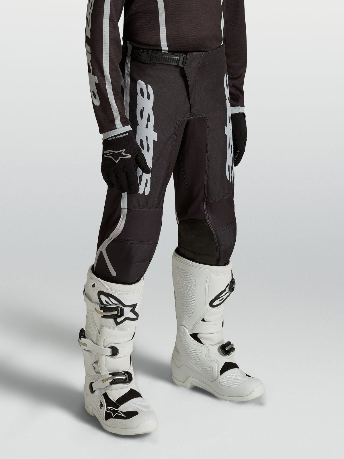 Pantalones Alpinestars Fluid Apex V2 Juvenil, equipo de motocross negro y plateado con ajuste ergonómico precurvado.