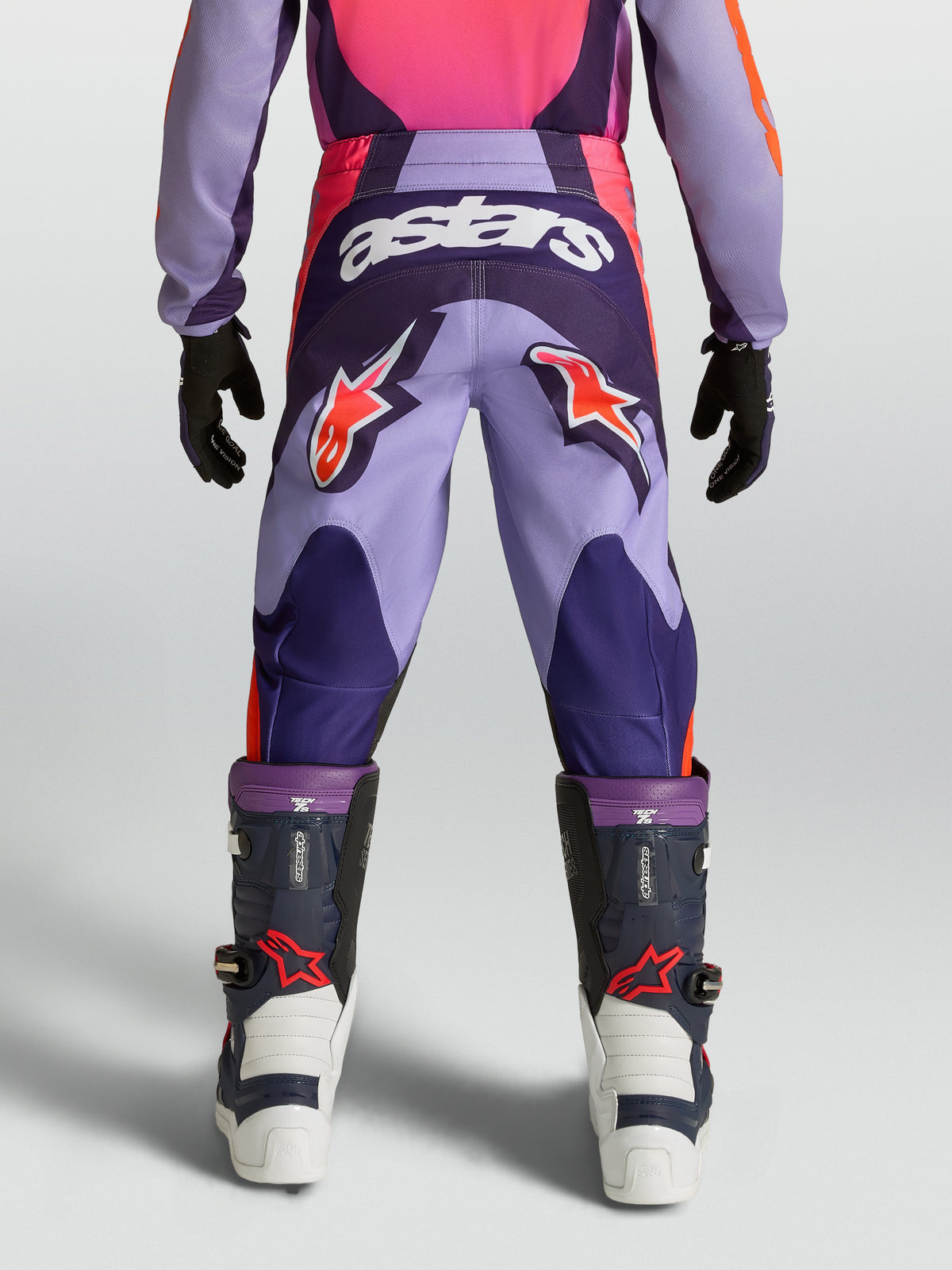 Alpinestars Youth Fluid Hunt Pants, purple and pink motocross racing gear with star logos and durable textile construction.