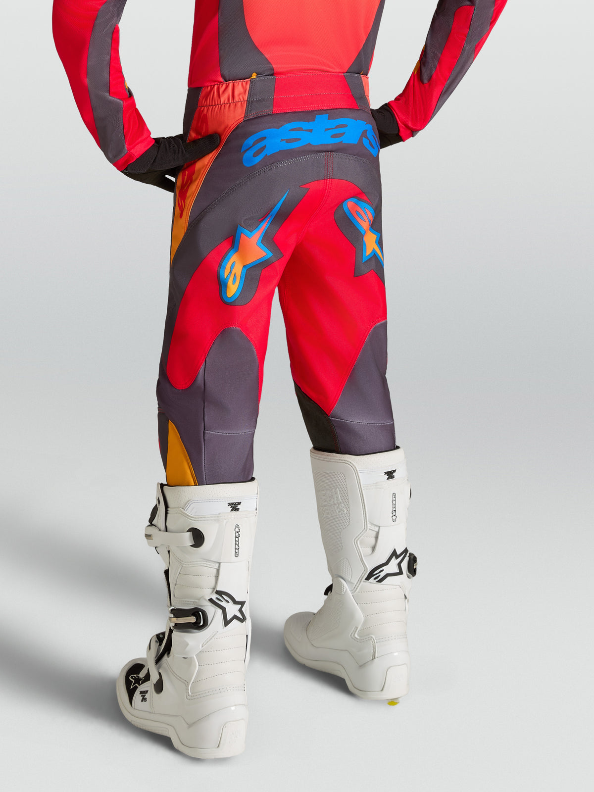 Alpinestars pantalones Fluid Hunt Juvenil, pantalones de motocross rojos y grises, con asiento reforzado de 600D y diseño ergonómico para pilotaje off-road, vista trasera