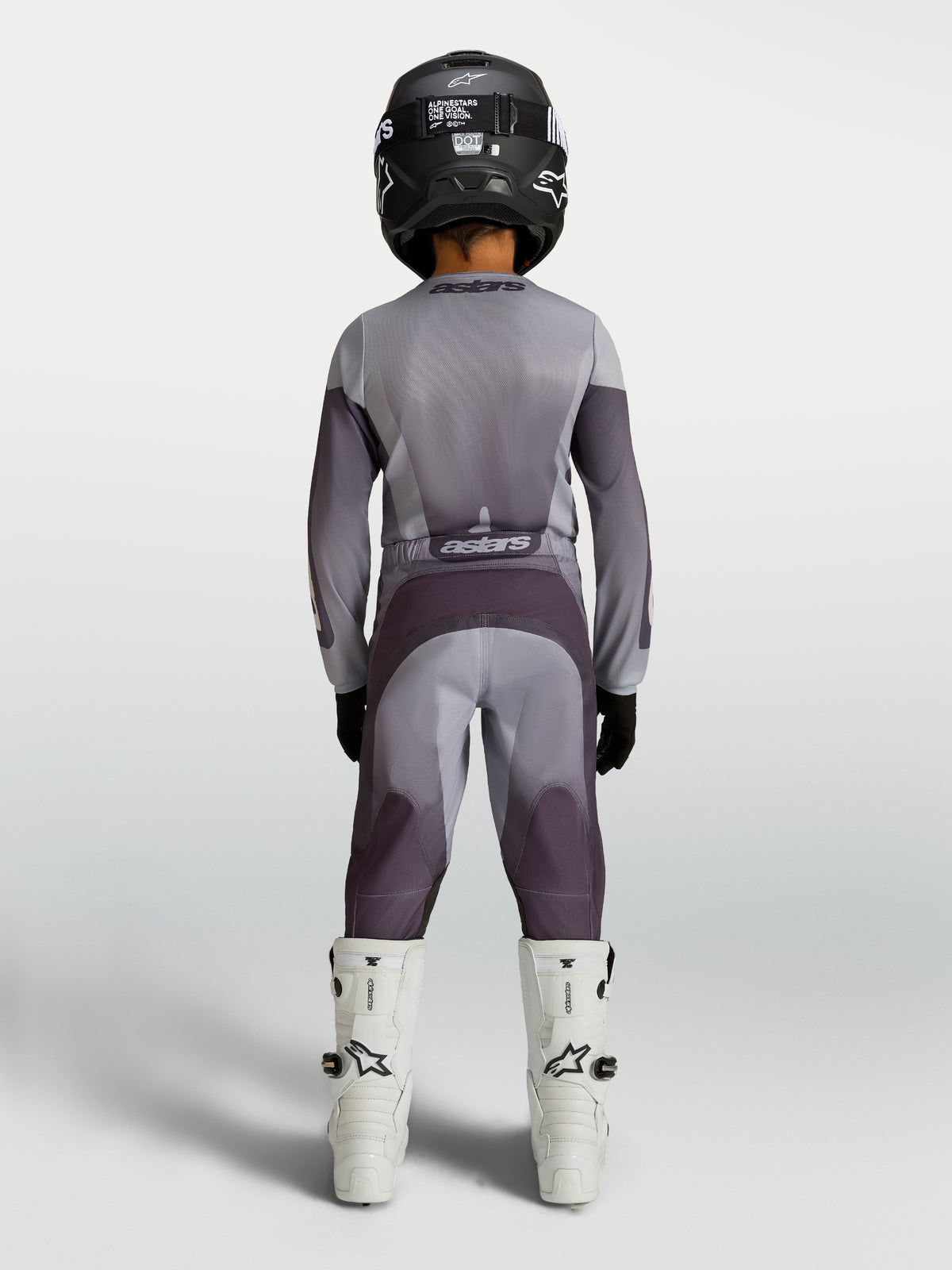 Alpinestars Youth Fluid Amber Pants in sand and gray, durable youth motocross pants shown from behind on a rider.