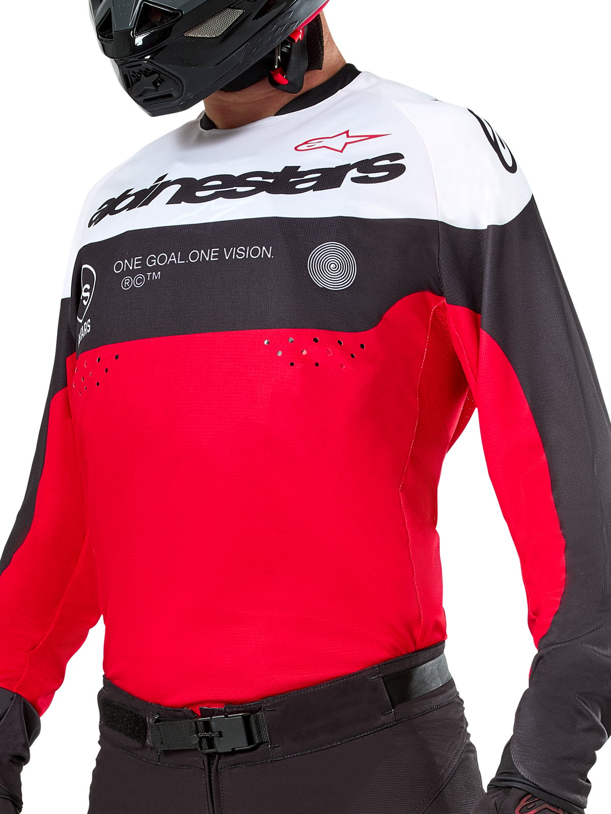 Jersey Alpinestars Pro-Dura, jersey de motocross y enduro, negro, rojo brillante y blanco, con gráfico 'ONE GOAL. ONE VISION.' y perforaciones láser en el pecho, usado con pantalones de motocross negros y casco.