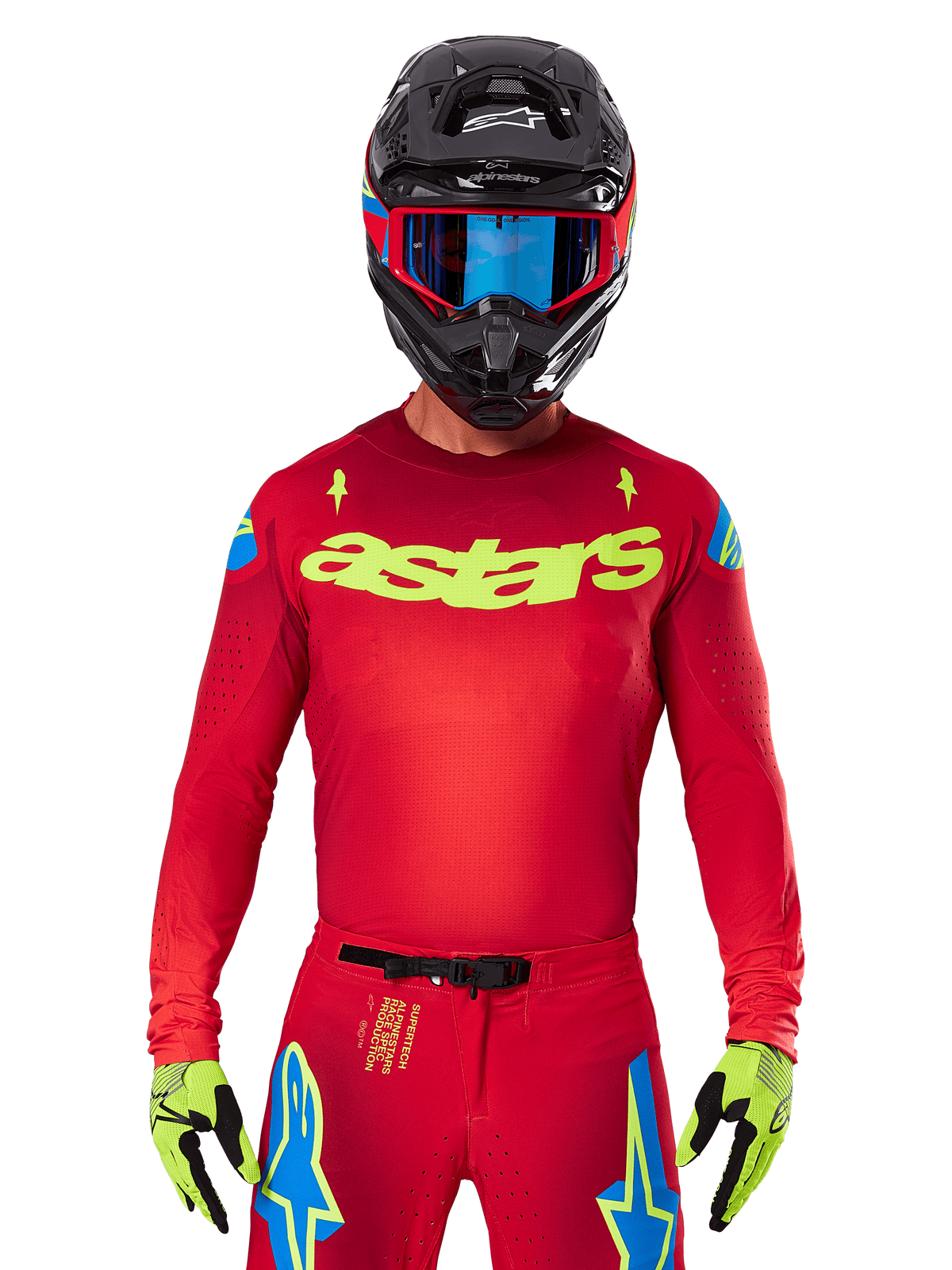 Jersey Alpinestars 2025 Supertech Maker en rojo brillante y amarillo flúor, con el logotipo 'astars' amarillo en el pecho y diseños de estrellas azules en los hombros, combinado con pantalones a juego, casco negro, gafas azules y guantes amarillos, equipamiento profesional de motocross