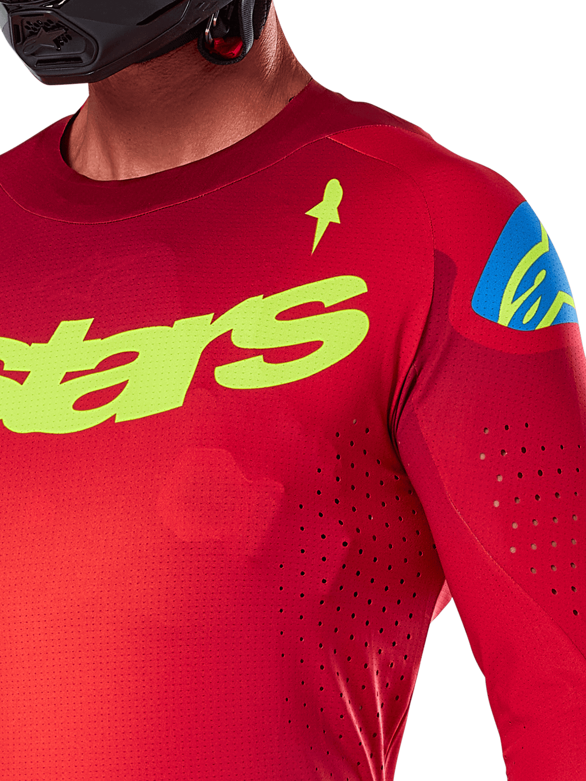Alpinestars 2025 Supertech Maker Jersey, jersey de motocross, rojo brillante y amarillo flúor, primer plano que muestra las perforaciones cortadas con láser, marca Alpinestars en amarillo en el pecho, detalle azul en el hombro, tejido de malla elástica transpirable