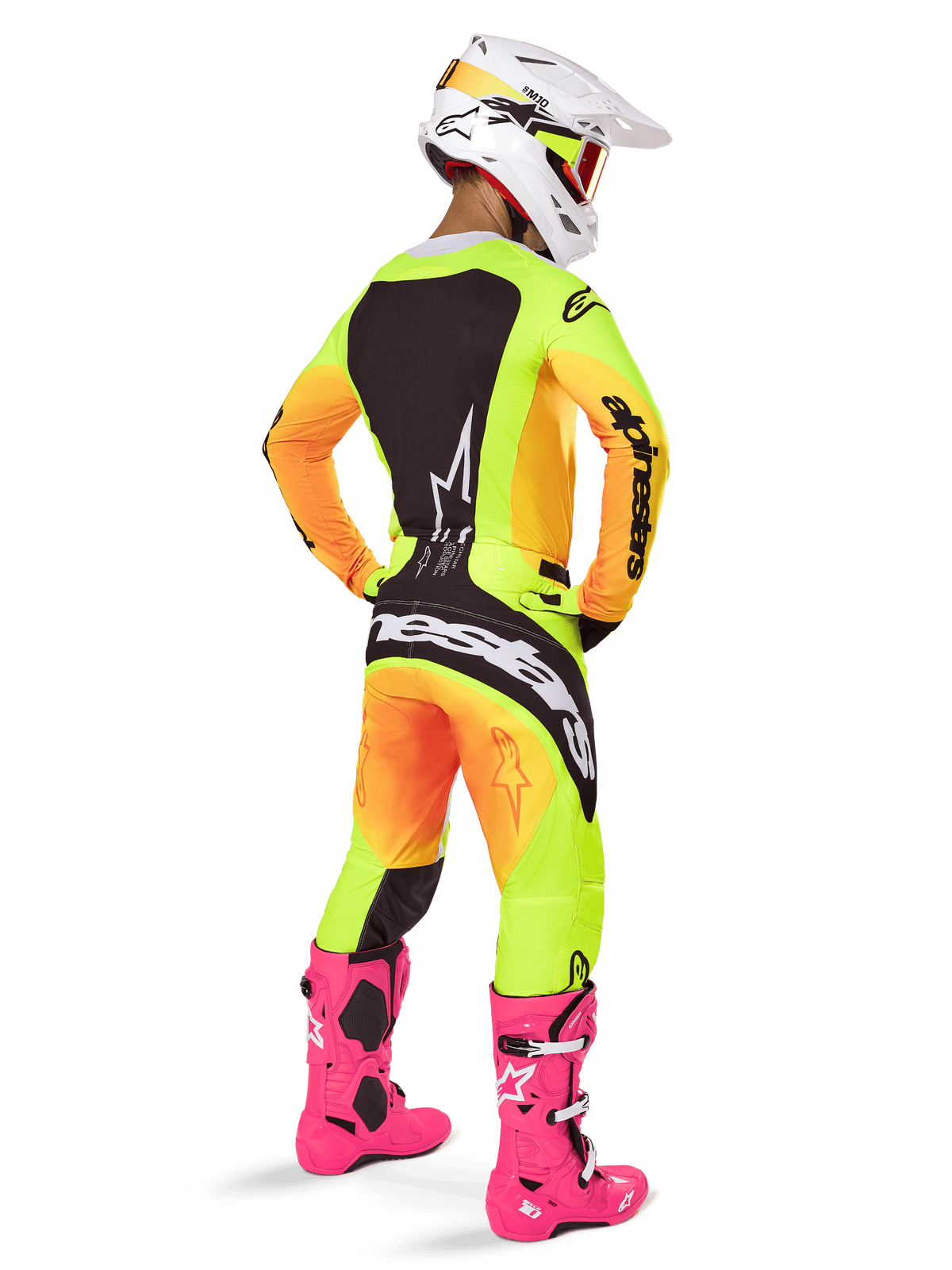 Piloto de motocross desde atrás con el jersey Alpinestars 2025 Techstar Melt, degradado vibrante de amarillo y naranja con secciones negras, pantalones de motocross a juego, botas rosa brillante y casco blanco, diseño de ajuste atlético para competición off-road