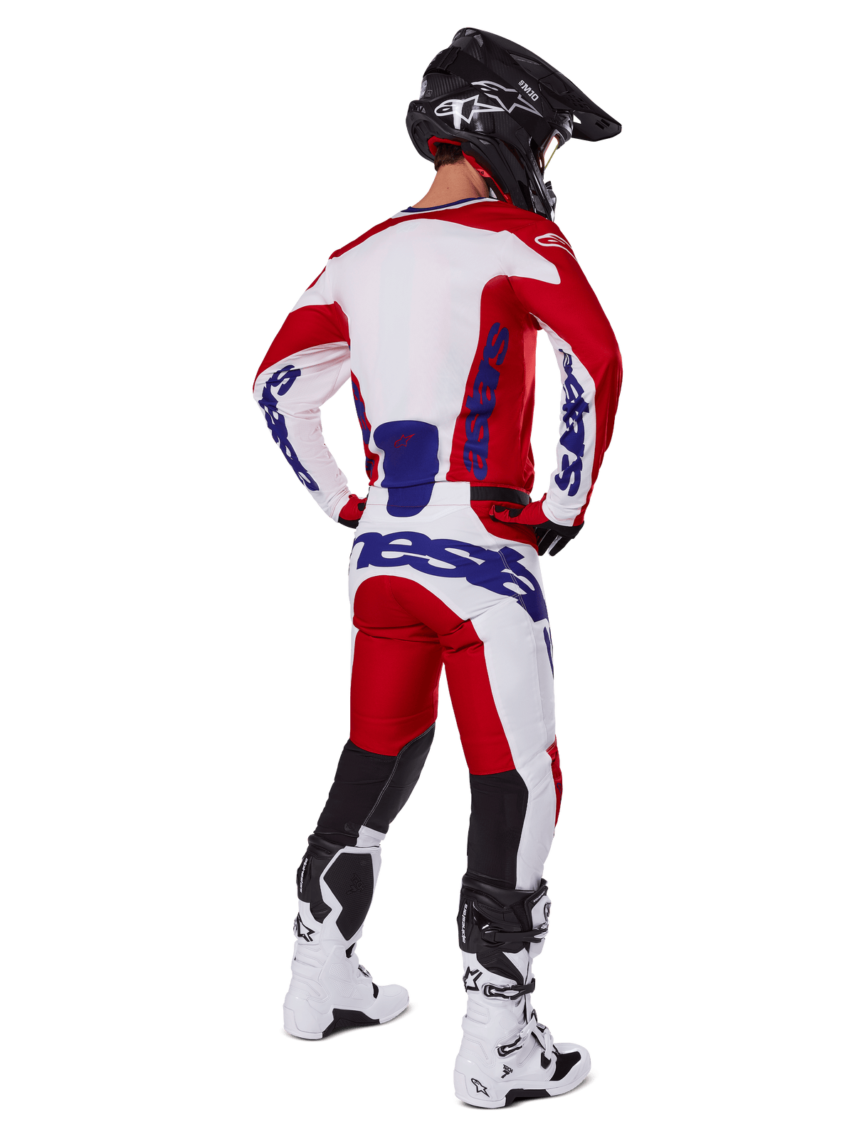 Motocross rider shown from behind wearing the Alpinestars 2025 Racer Veil Jersey and Pants in Red and White, featuring blue branding, black helmet, and white boots, complete gear set for off-road racing