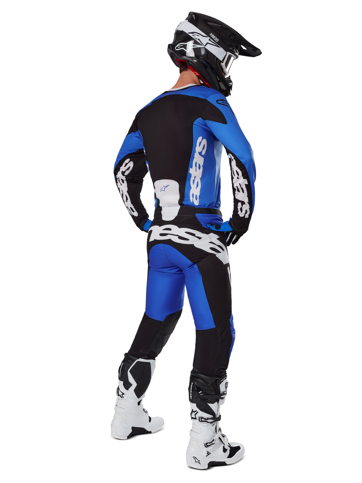 Motocross rider wearing complete racing gear seen from behind, 2025 Racer Veil Jersey and matching pants in Blue and Black, featuring white Alpinestars branding, black helmet, white and black boots, coordinated outfit for off-road racing
