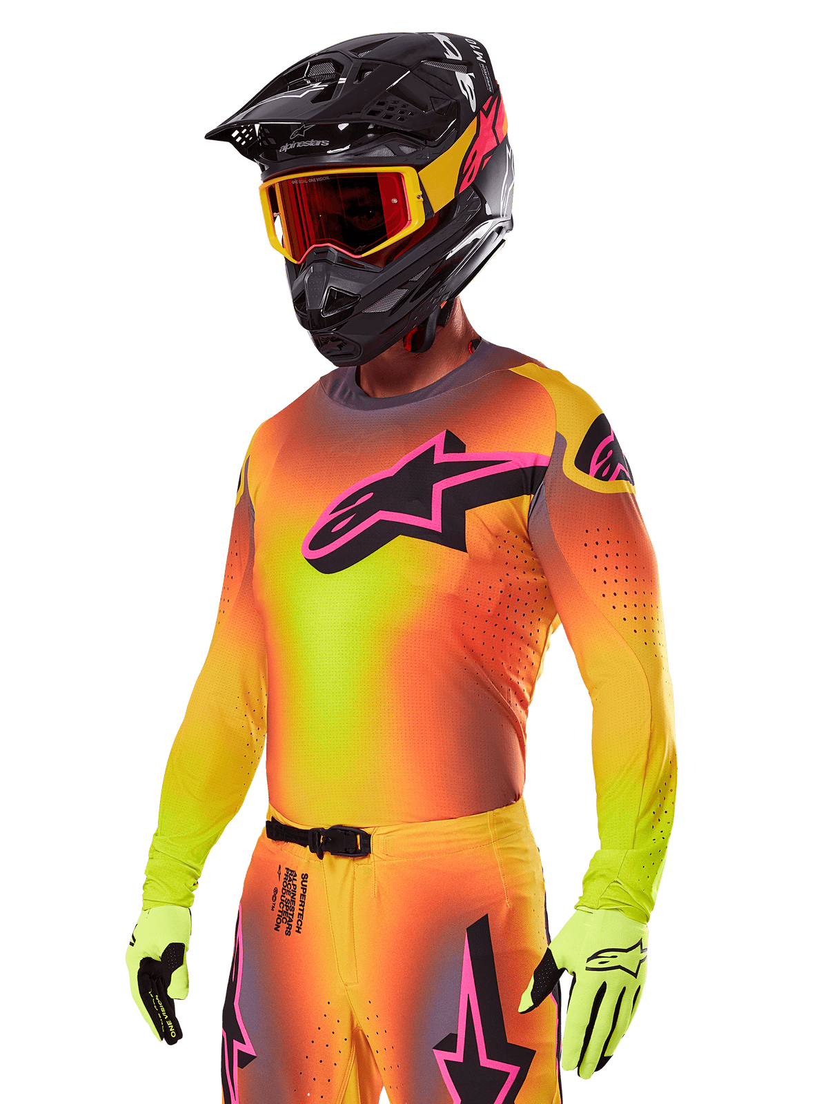 Motocross rider wearing the Alpinestars 2025 Supertech Lipan Gear Set, featuring a yellow and orange gradient jersey with a pink and black Astars logo, neon yellow gloves, and a black helmet with red goggles, professional off-road racing gear.
