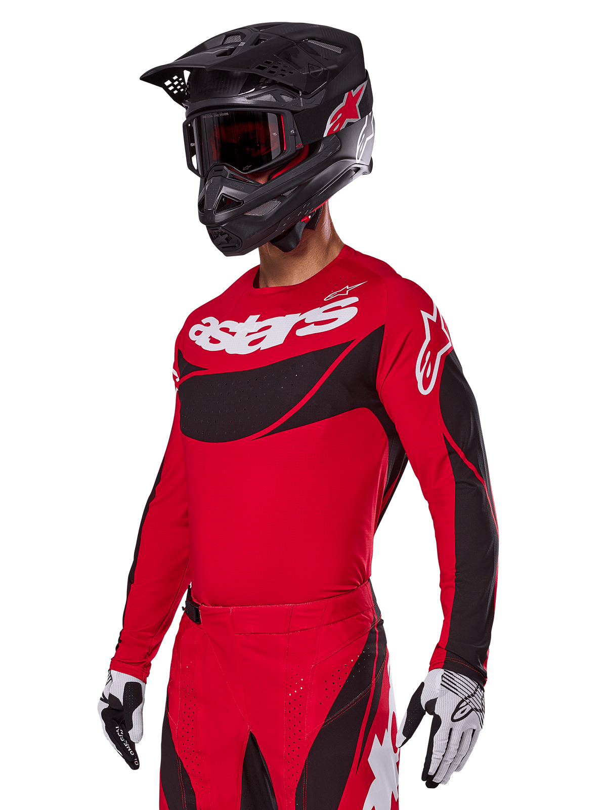 Alpinestars 2025 Techstar Dreem Gear Set, conjunto de jersey y pantalones de motocross rojos con detalles en negro y blanco, usado con casco y gafas negros, guantes blancos y negros, con el logotipo 'astars' destacado, diseñado para competición off-road de alto rendimiento