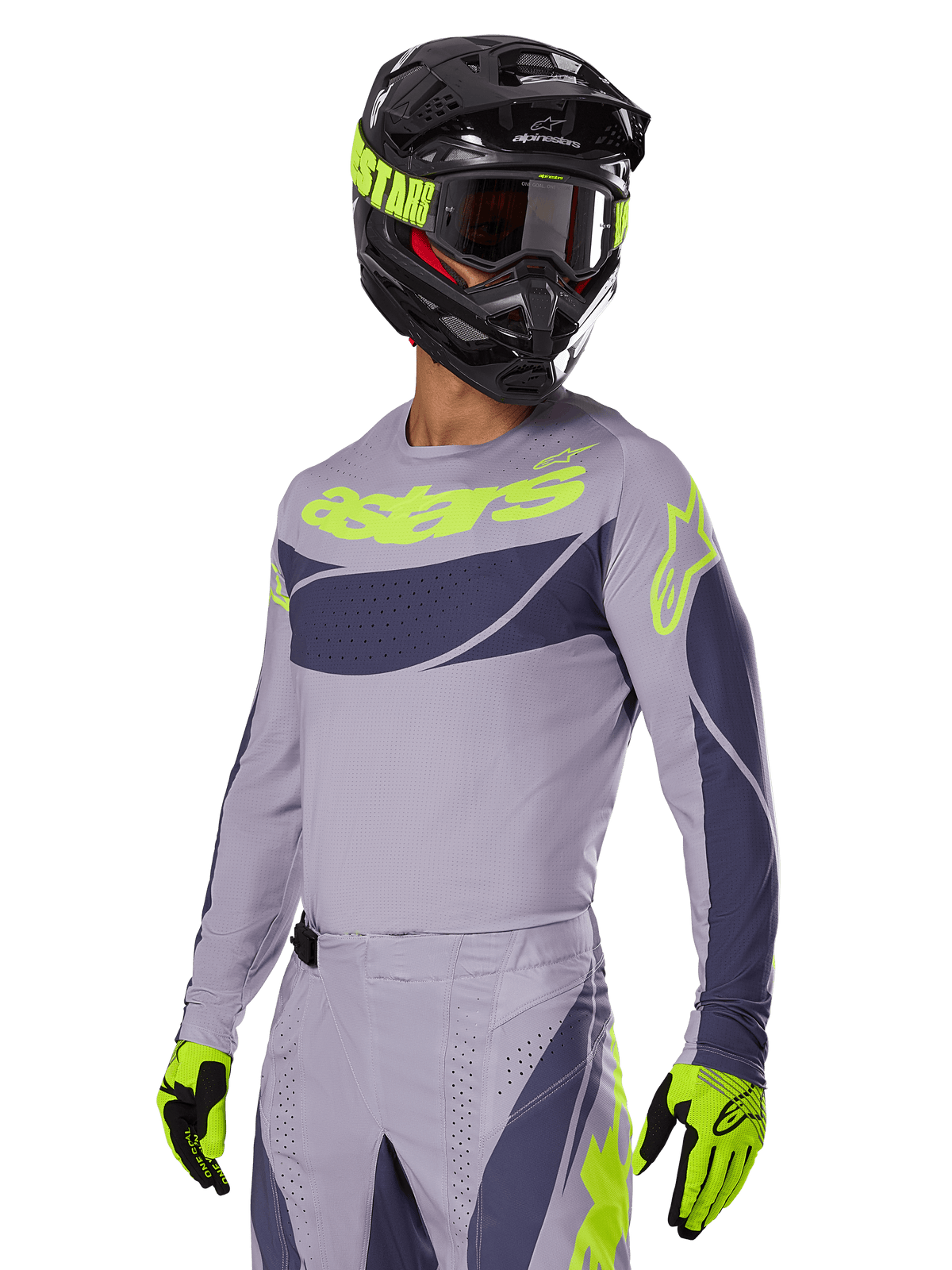 Piloto de motocross con el jersey Alpinestars 2025 Techstar Dreem en gris y gris oscuro, que presenta el logotipo 'astars' en amarillo neón en el pecho, combinado con casco, gafas y guantes a juego para un look coordinado de carreras off-road