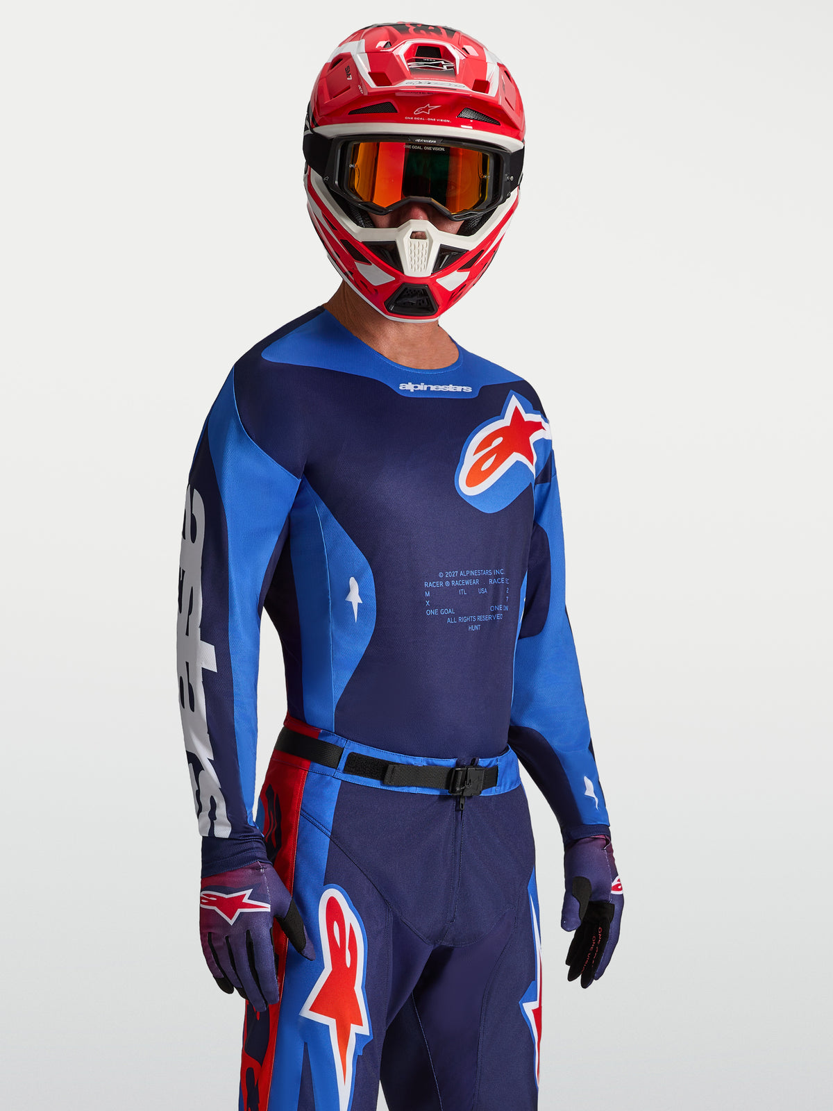 Jersey Racer Hunt Alpinestars, jersey de motocross en azul fuerte y rojo fuego, tejido técnico transpirable usado por un modelo.