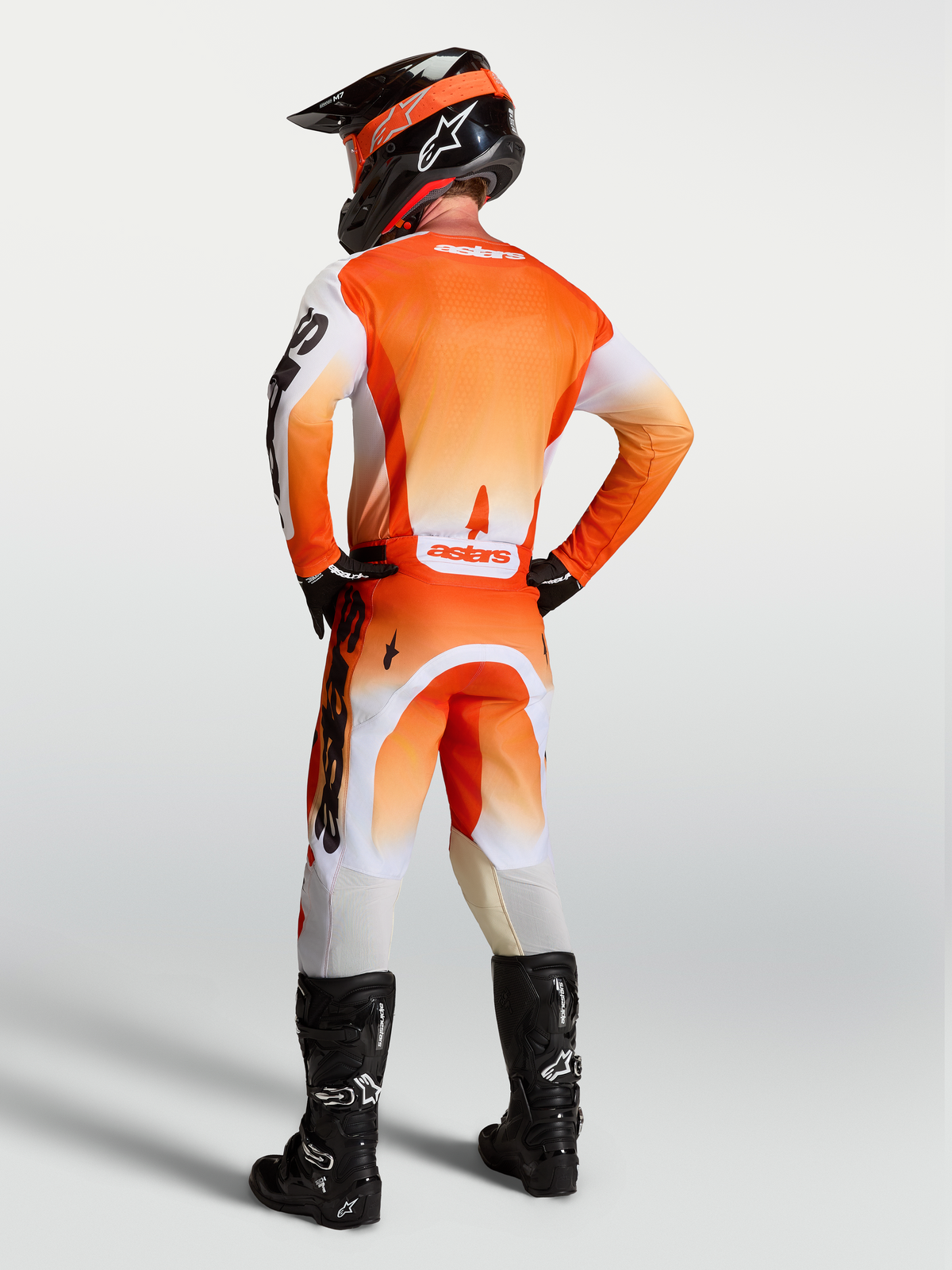 Alpinestars Racer Amber Pants, men's orange and white motocross gear, on-model rear view with race-fit construction.