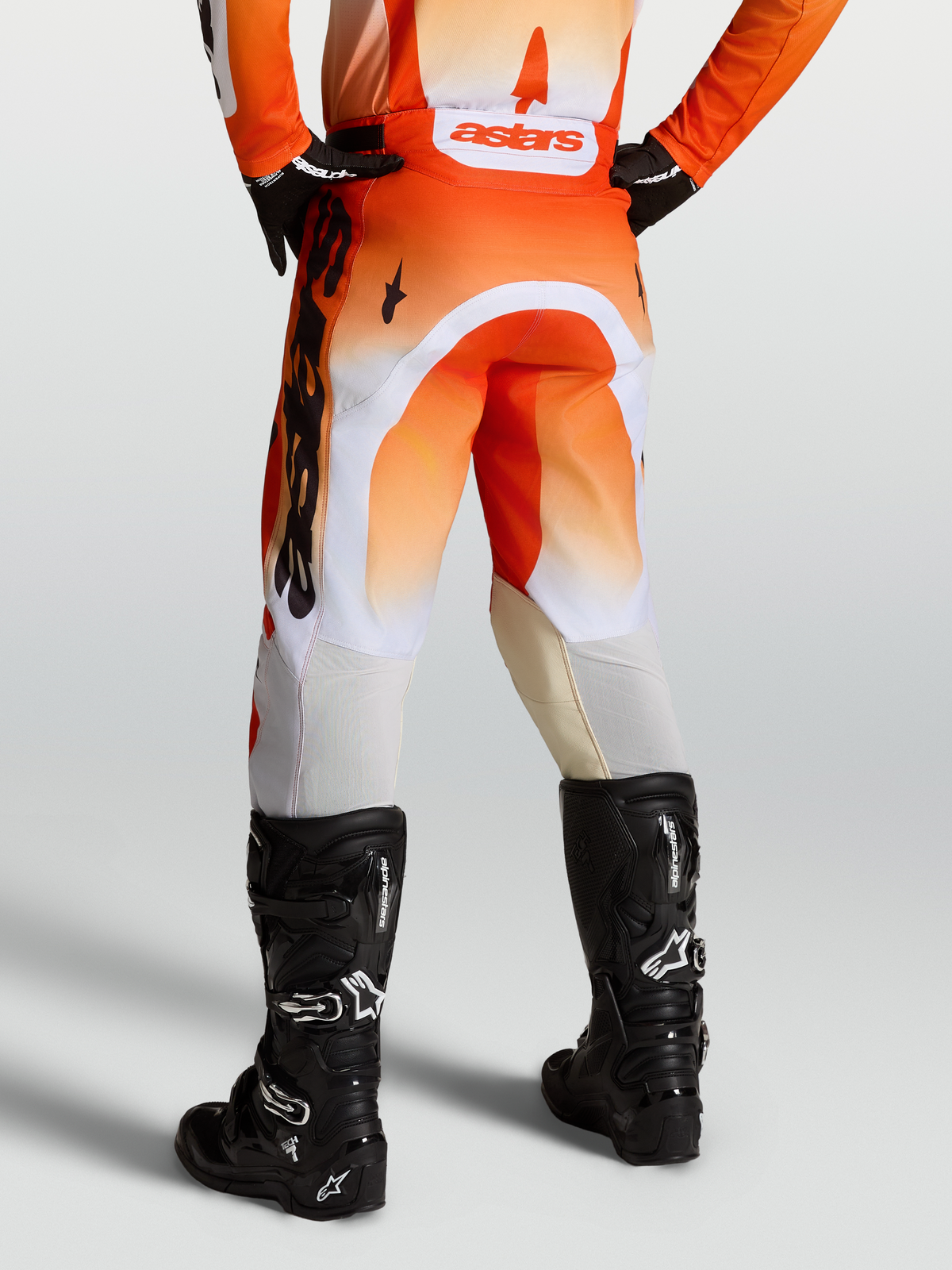 Alpinestars Pantalones Racer Amber, pantalones de motocross para hombre en rojo y blanco con botas negras, ajuste de carrera precurvado y tejido duradero