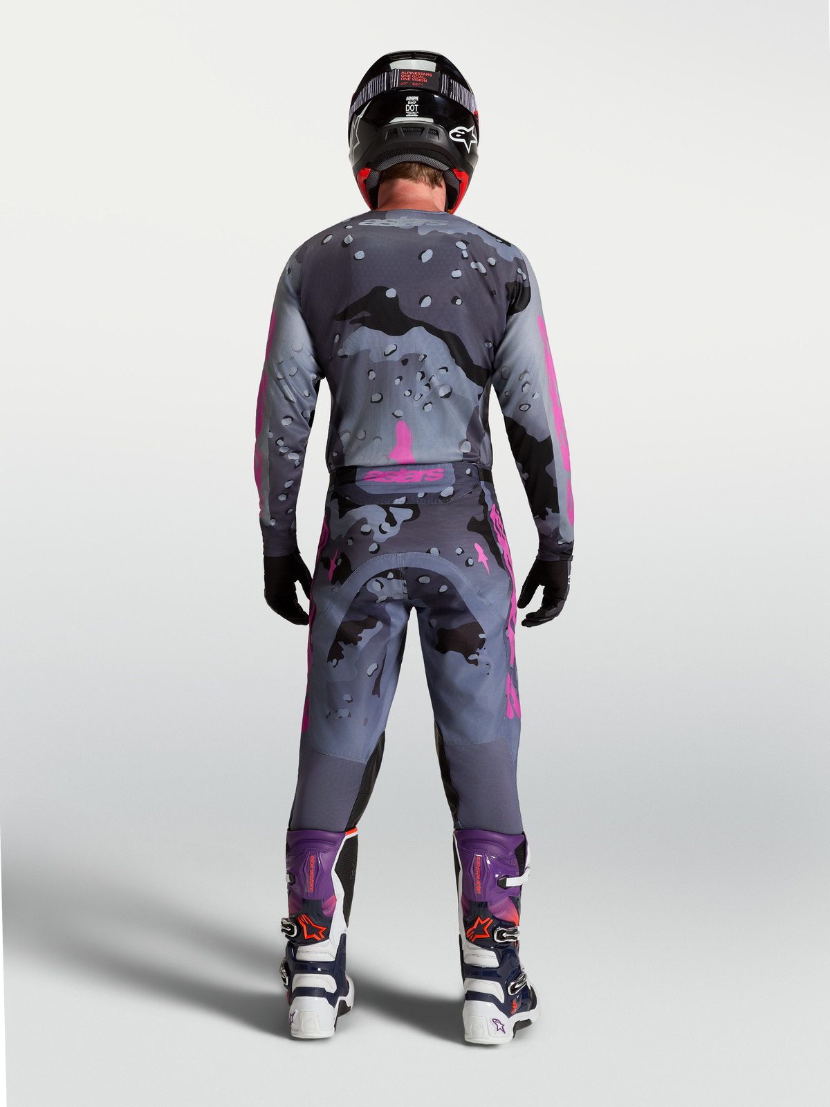 Racer Lone Gear Set de Alpinestars, conjunto de motocross para hombre gris y morado con camuflaje, vista trasera del piloto.