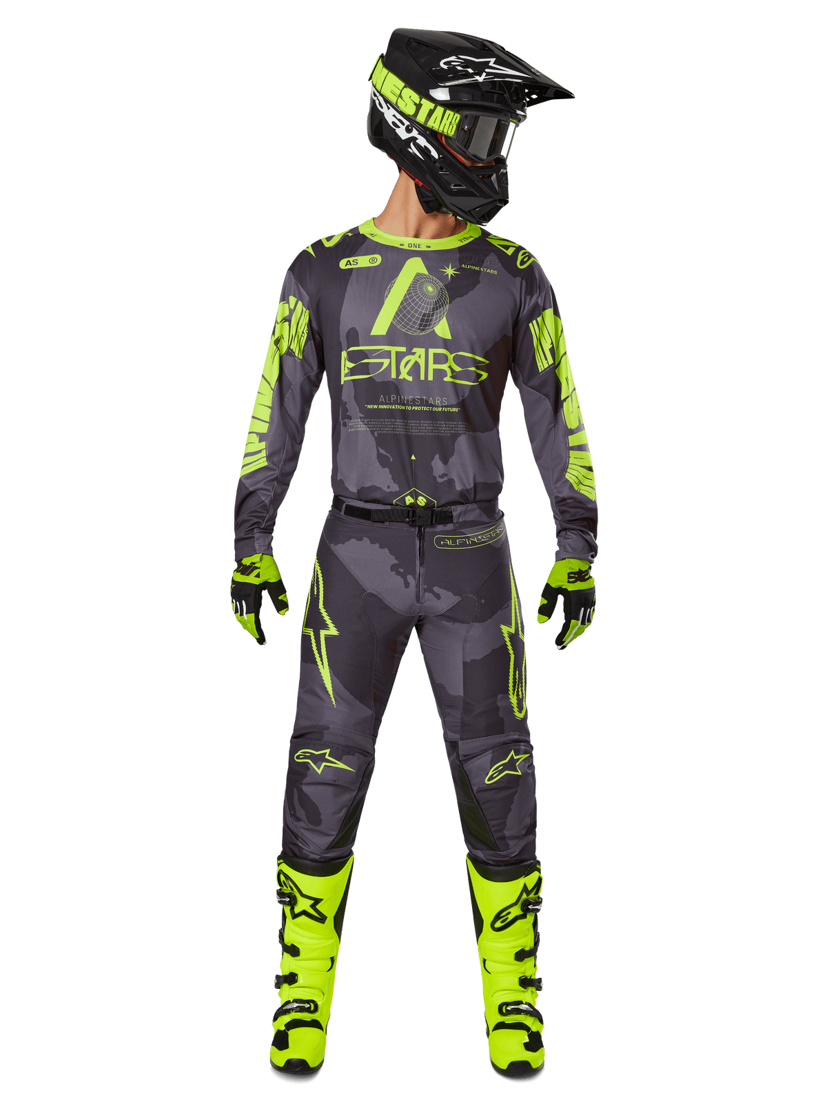 Piloto de motocross con equipamiento completo de carreras, jersey Alpinestars Racer Hollow 2025 y pantalones a juego en color Dark Camo Yellow Fluo, con gráficos llamativos en amarillo flúor sobre un fondo de camuflaje gris oscuro, combinado con guantes a juego, botas en amarillo flúor brillante y casco negro.