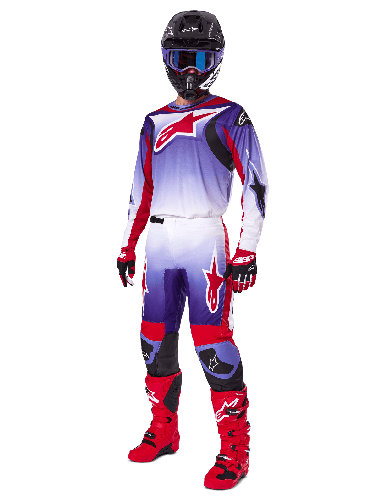 Piloto de motocross con el conjunto Alpinestars 2025 Fluid Wurx, jersey púrpura y rojo brillante con detalles blancos, pantalones de motocross a juego, botas rojo brillante, casco negro con gafas azules y guantes rojos y negros, kit profesional completo de carreras todoterreno