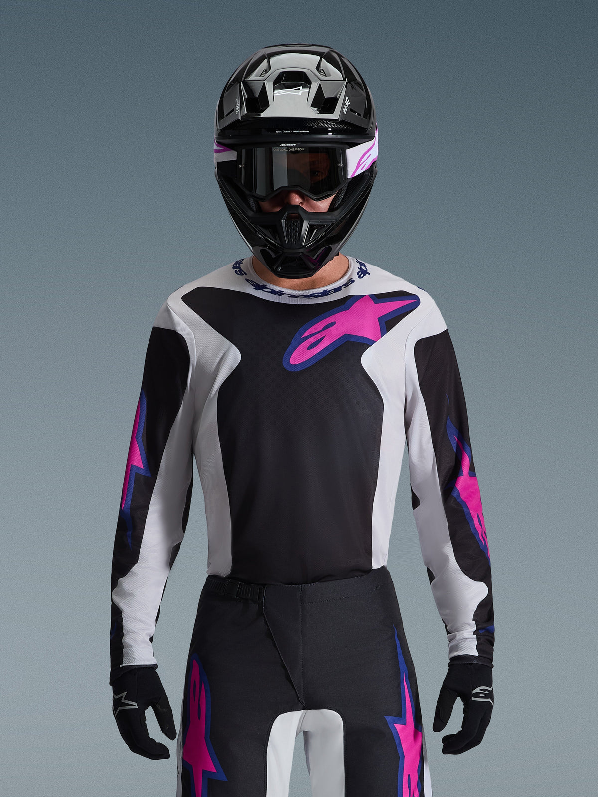 Alpinestars 2026 Fluid Grid Gear Set, Motocross rider wearing a black, white, and pink jersey with matching pants, black helmet with pink and white accents, coordinated professional racing outfit for off-road performance