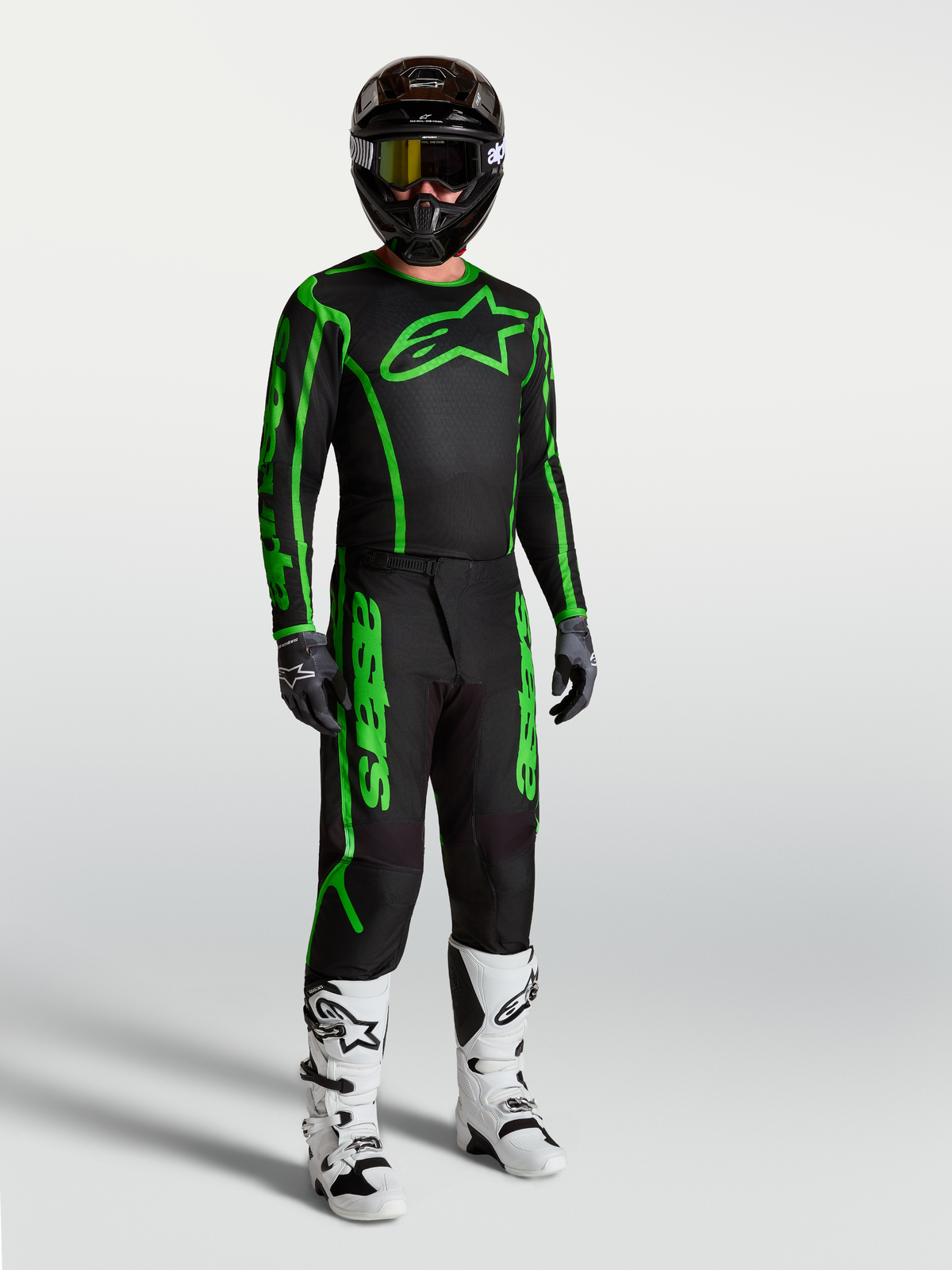 Alpinestars jersey Fluid Apex V2 negro y verde flúor para motocross de hombre, mostrado con pantalones y botas.
